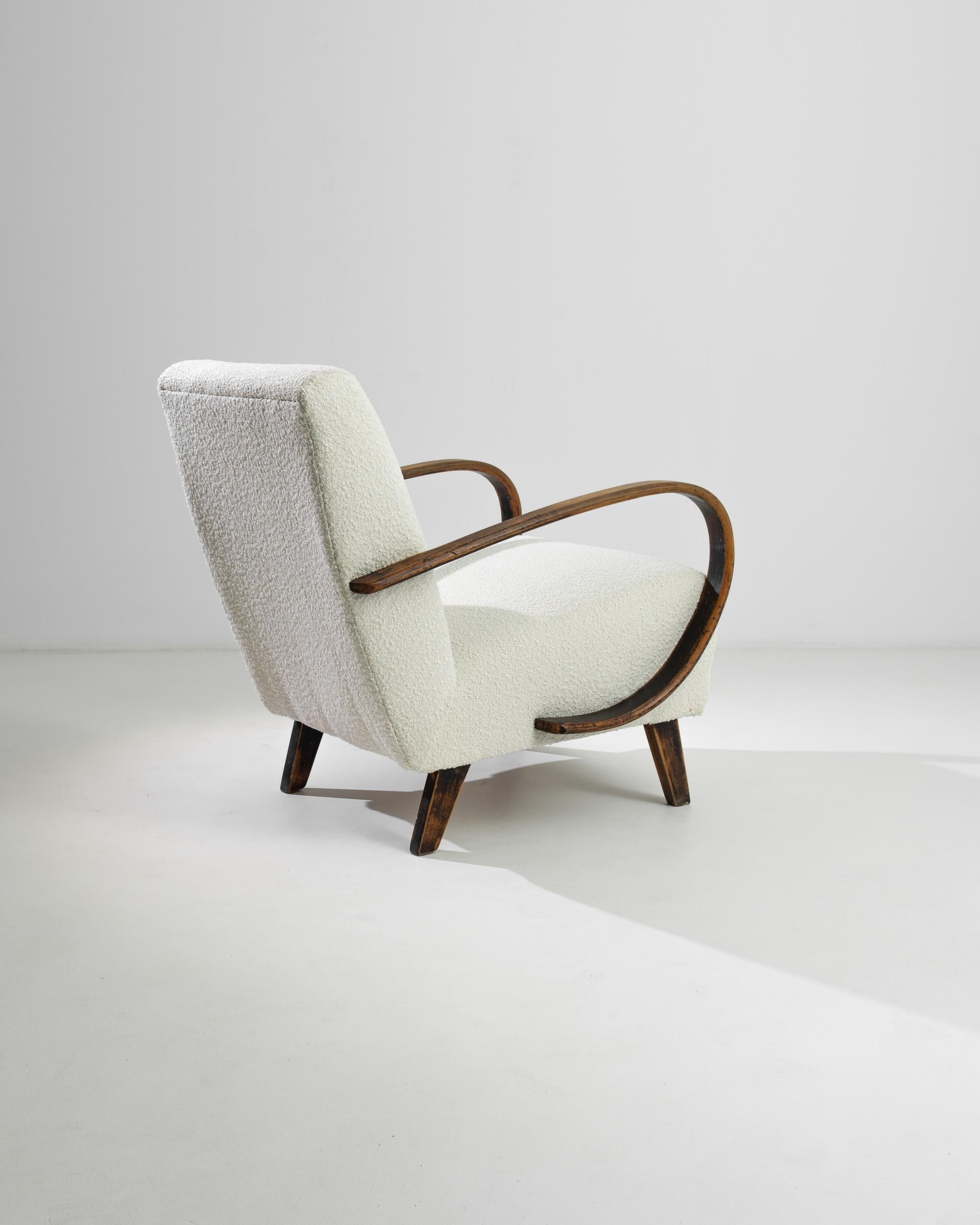 Entra nel mondo del lusso vintage con questa poltrona imbottita ceca degli anni '50 del leggendario Jindřich Halabala. Questa elegante poltrona presenta gli iconici braccioli e le gambe in legno graziosamente curvate di Halabala, offrendo un mix