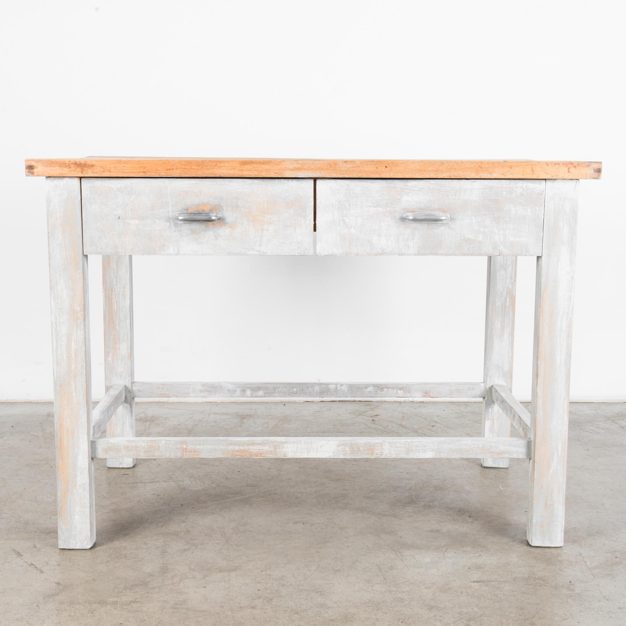 A wood patinated table from Czechia, produced, circa 1950. A sturdy table with a thick tabletop and two drawers straight from a mid-century workshop. A muted palette and unencumbered design allow this piece to function in most any environment.