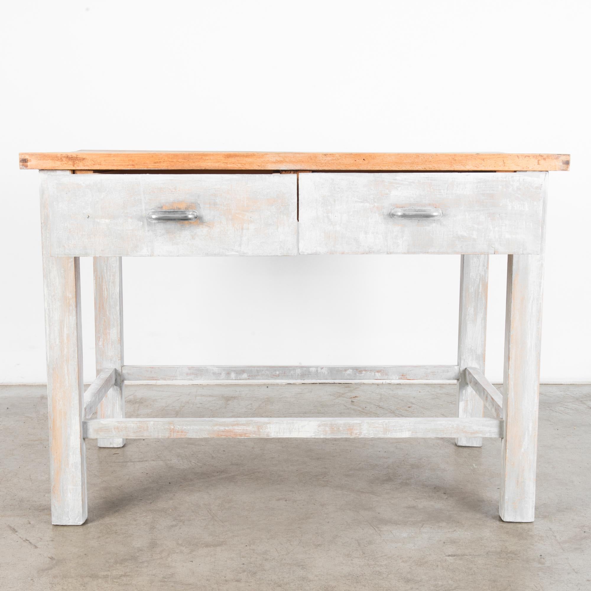 A wood patinated table from Czechia, produced, circa 1950. A sturdy table with a thick tabletop and two drawers straight from a mid-century workshop. A muted palette and unencumbered design allow this piece to function in most any environment.