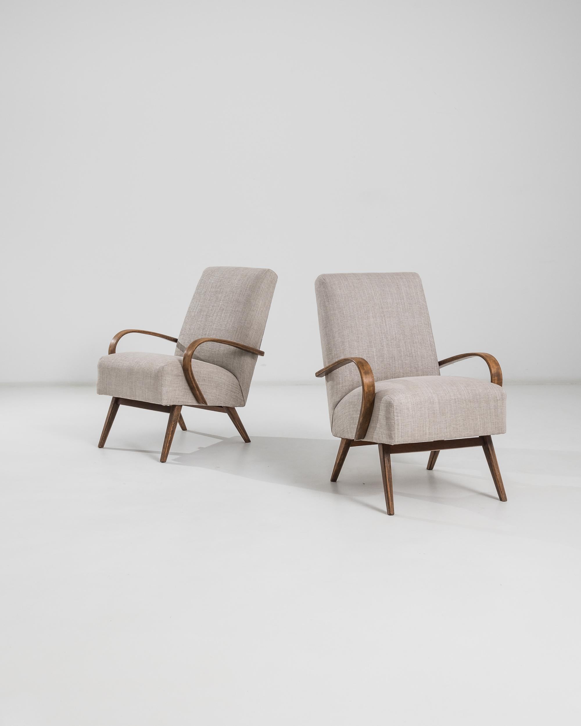 Elevate your living space with this exquisite pair of 1950s Czech Wooden Armchairs by the renowned designer J. Halabala. These mid-century modern chairs boast a timeless elegance with their sleek lines and graceful curves. The sturdy wooden frame is