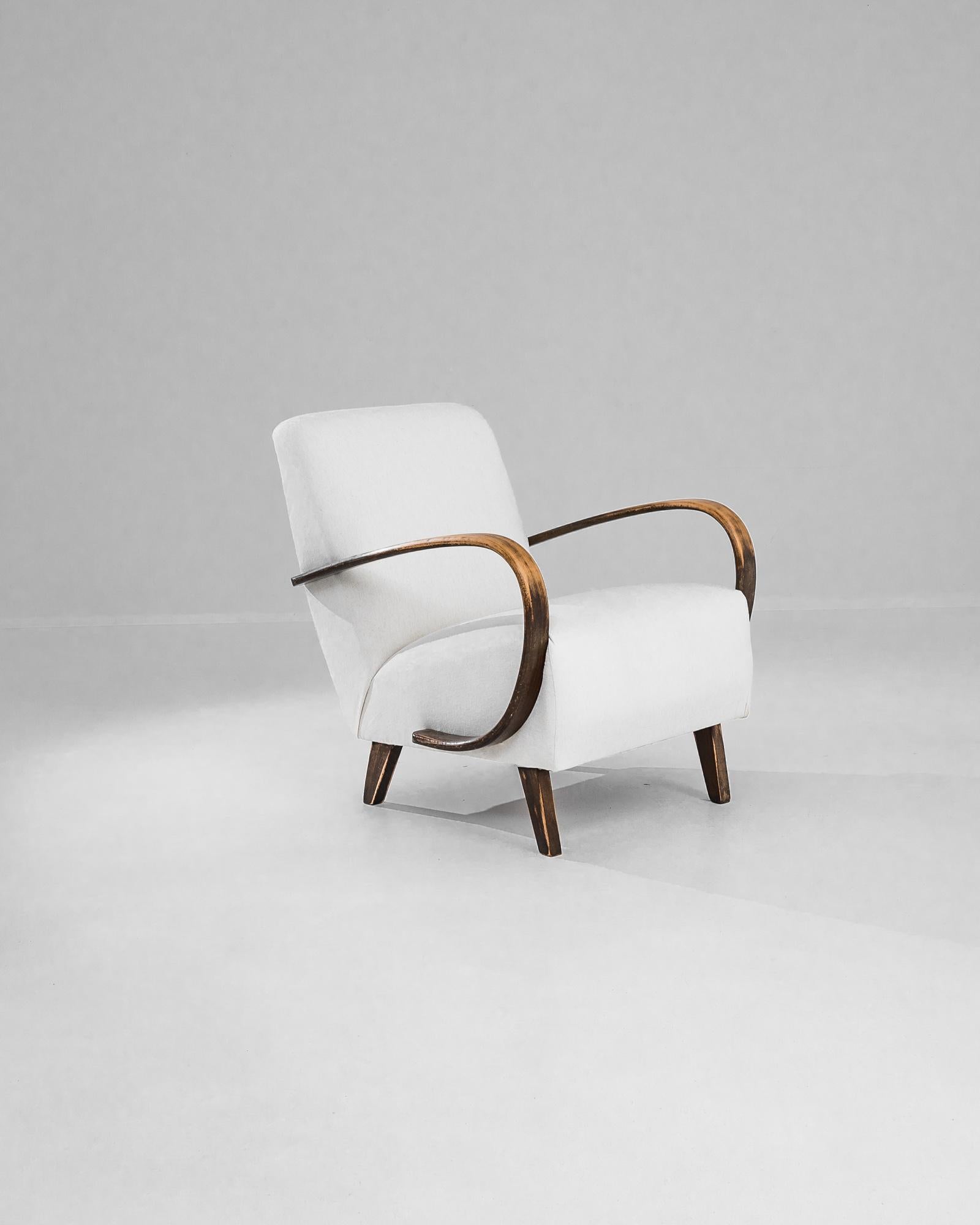 Add a touch of Art Deco elegance to your home with this stunning 1950s Czech Wooden Armchair by J. Halabala. Renowned for his innovative designs, Halabala's craftsmanship is evident in this exquisite piece, featuring gracefully curved wooden