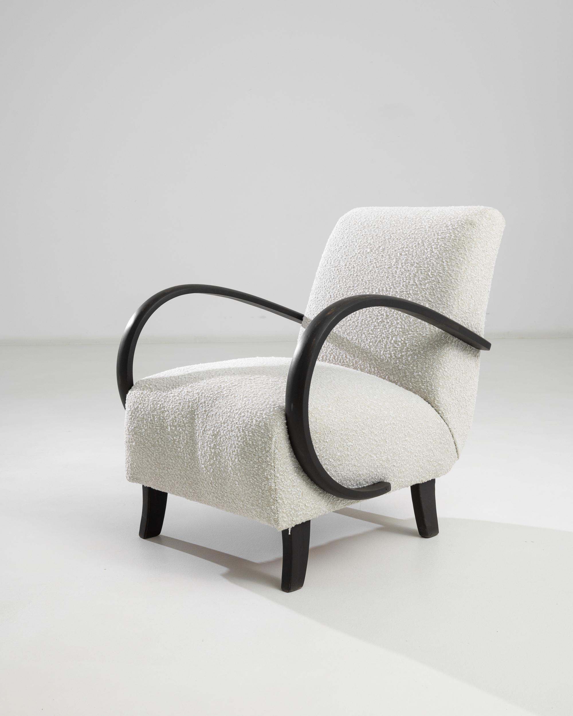 Introducing the 1950s Czech Wooden Armchair by J. Halabala, a timeless piece that combines vintage charm with modern comfort. This exquisite armchair features elegantly curved wooden armrests that provide a striking contrast to its plush, textured