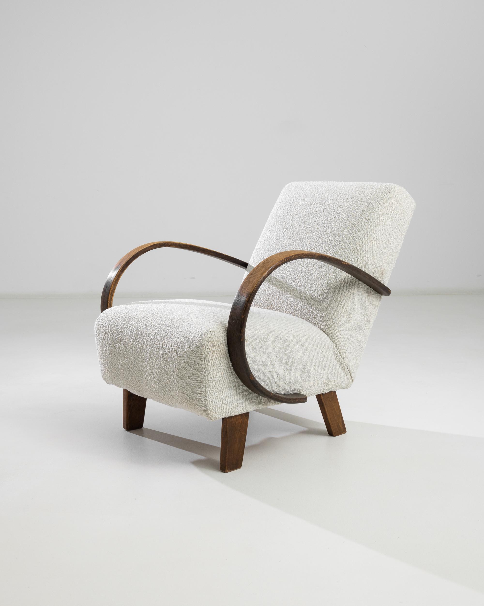 Introducing the 1950s Czech Wooden Armchair by J. Halabala, a timeless piece that combines vintage charm with modern comfort. This exquisite armchair features elegantly curved wooden armrests that provide a striking contrast to its plush, textured
