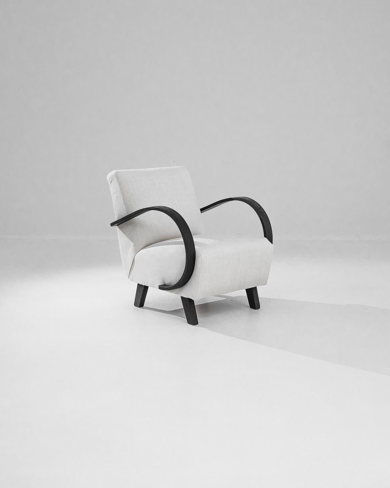 This 1950s Czech Wooden Armchair by Jindřich Halabala is a true masterpiece of mid-century modern design. Known for his innovative approach to furniture, Halabala created this armchair with a striking balance of form and function. The chair features