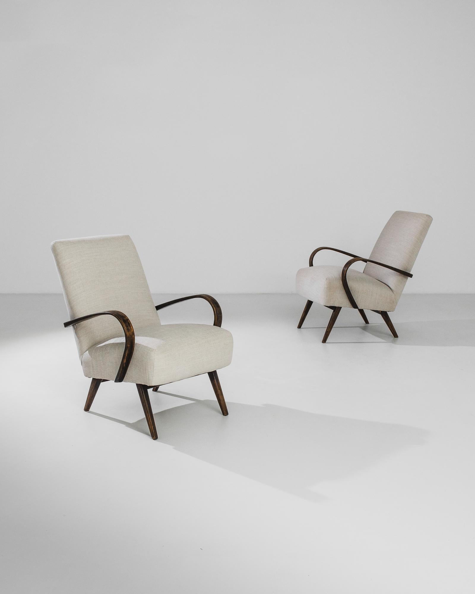Add a touch of vintage elegance to your home with this exquisite pair of 1950s Czech Wooden Armchairs by renowned designer Jindřich Halabala. These chairs are the epitome of mid-century modern design, featuring gracefully curved wooden arms that