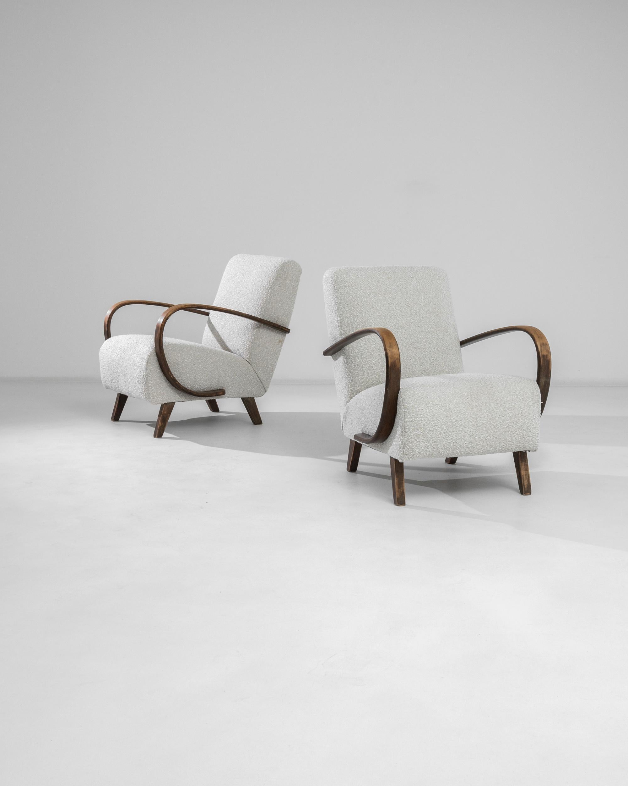 Introducing a pair of stunning 1950s Czech wooden chairs, a testament to the era's design innovation and style. These chairs exude a chic mid-century modern appeal, with their smooth, curving wooden armrests that provide a warm, natural contrast to