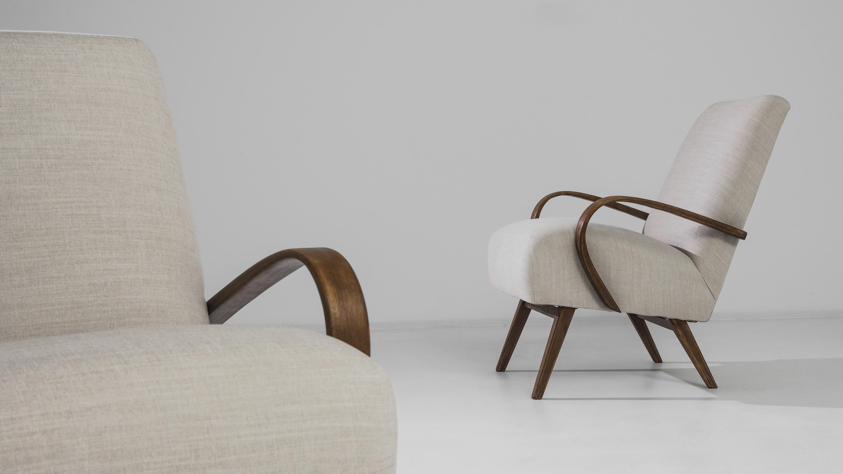 Ein Paar gepolsterte Sessel des tschechischen Möbeldesigners J. Halabala. Die auffällige Silhouette und das bequeme Design, das in den 1950er Jahren entwickelt wurde, haben einen bleibenden Reiz. Der tief gepolsterte Sitz auf geschwungenen Holzfüßen