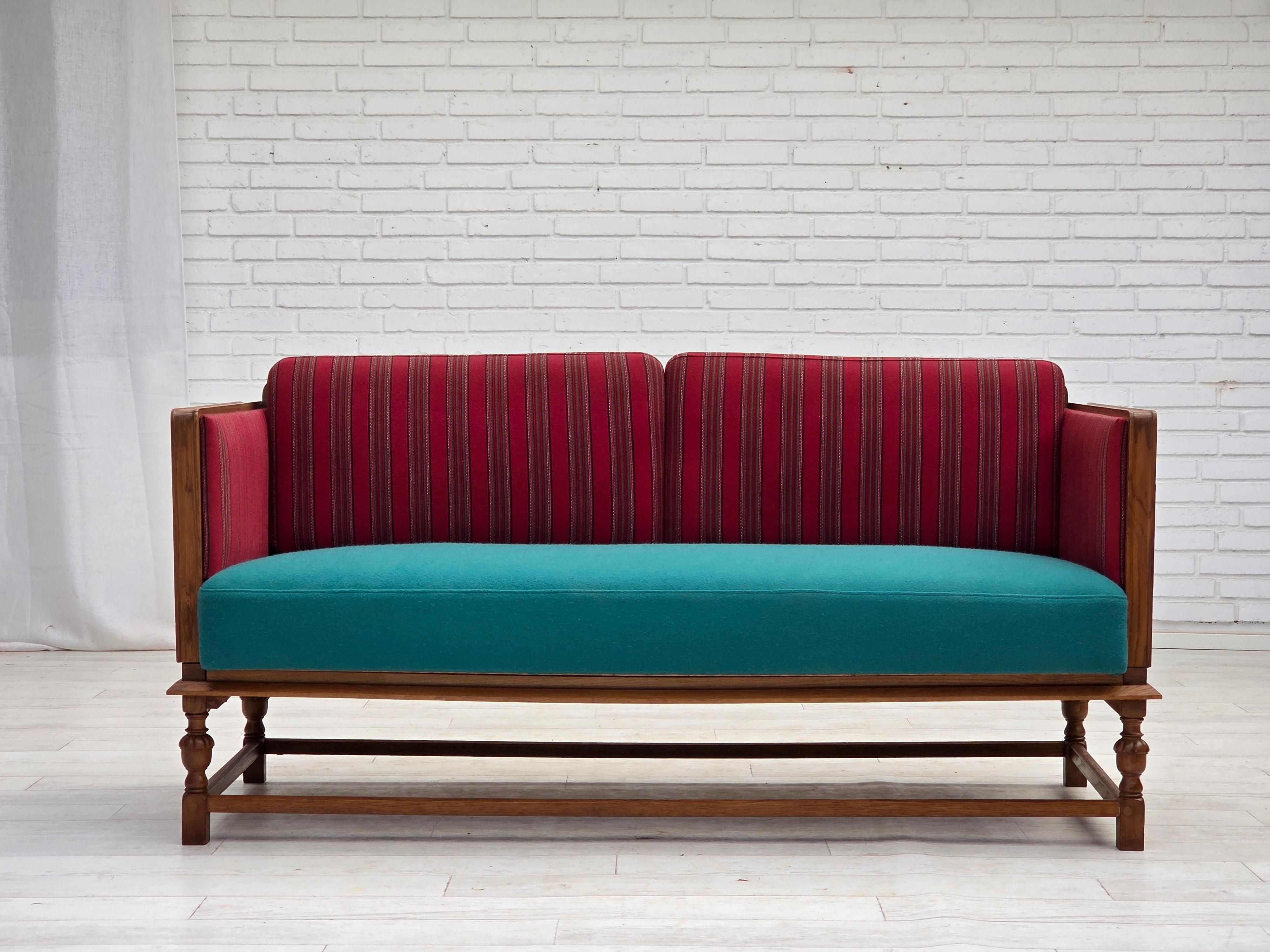 Canapé danois à 2 places et accoudoirs, années 1950. Meuble original en laine rouge rayée, bois de chêne. Siège retapissé il y a environ 10 ans par un artisan en laine d'ameublement vert/bleu clair. Ressorts en laiton dans les coussins d'assise et