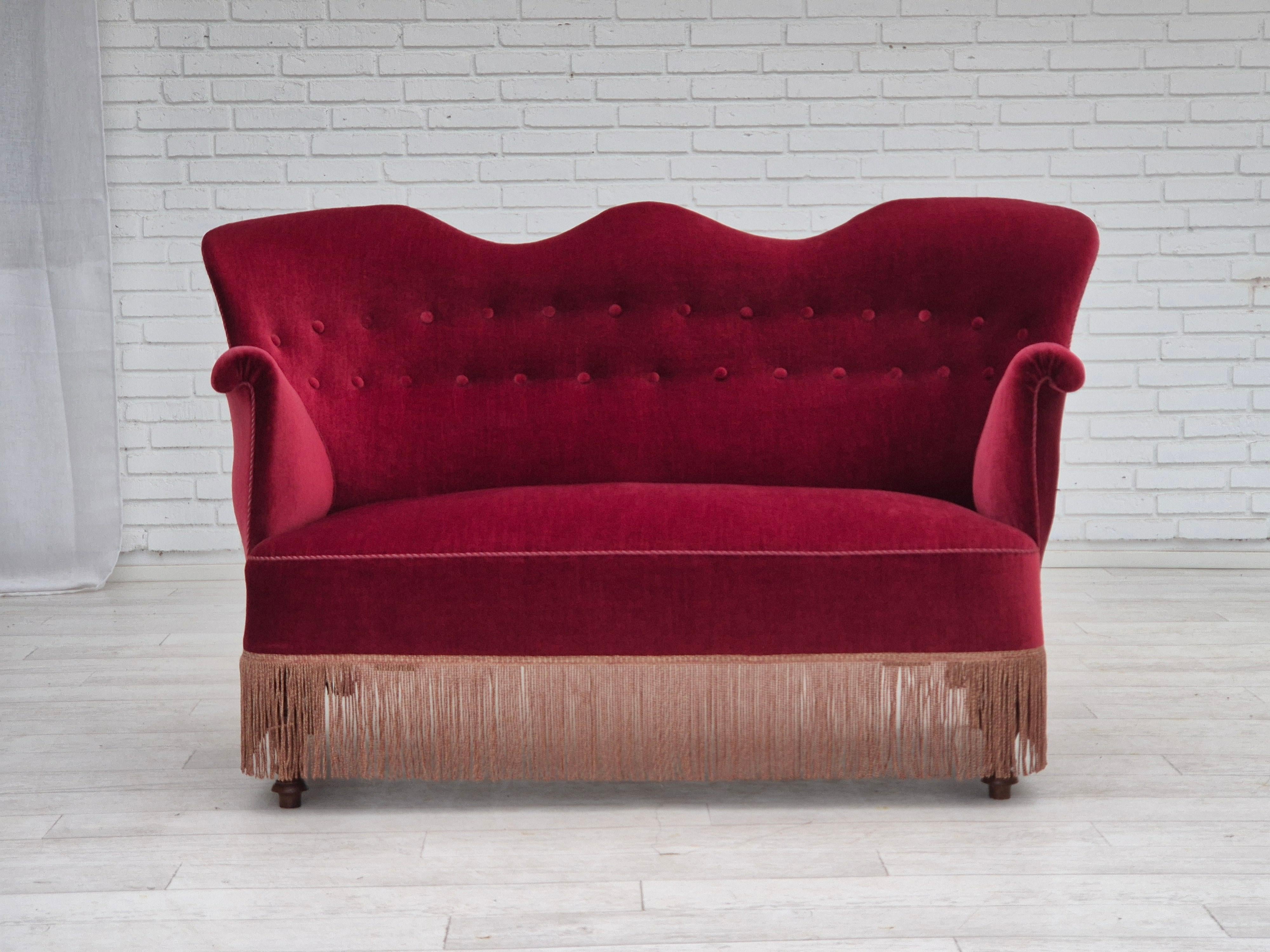 1950er Jahre, Dänisches 2-Sitzer-Sofa. Kirschroter Möbelvelours, Beine aus Eschenholz, Messingfedern in der Sitzfläche. Das Sofa wurde vor etwa 10 Jahren von einem Handwerker neu gepolstert. Sehr guter Zustand: keine Gerüche, keine Flecken und