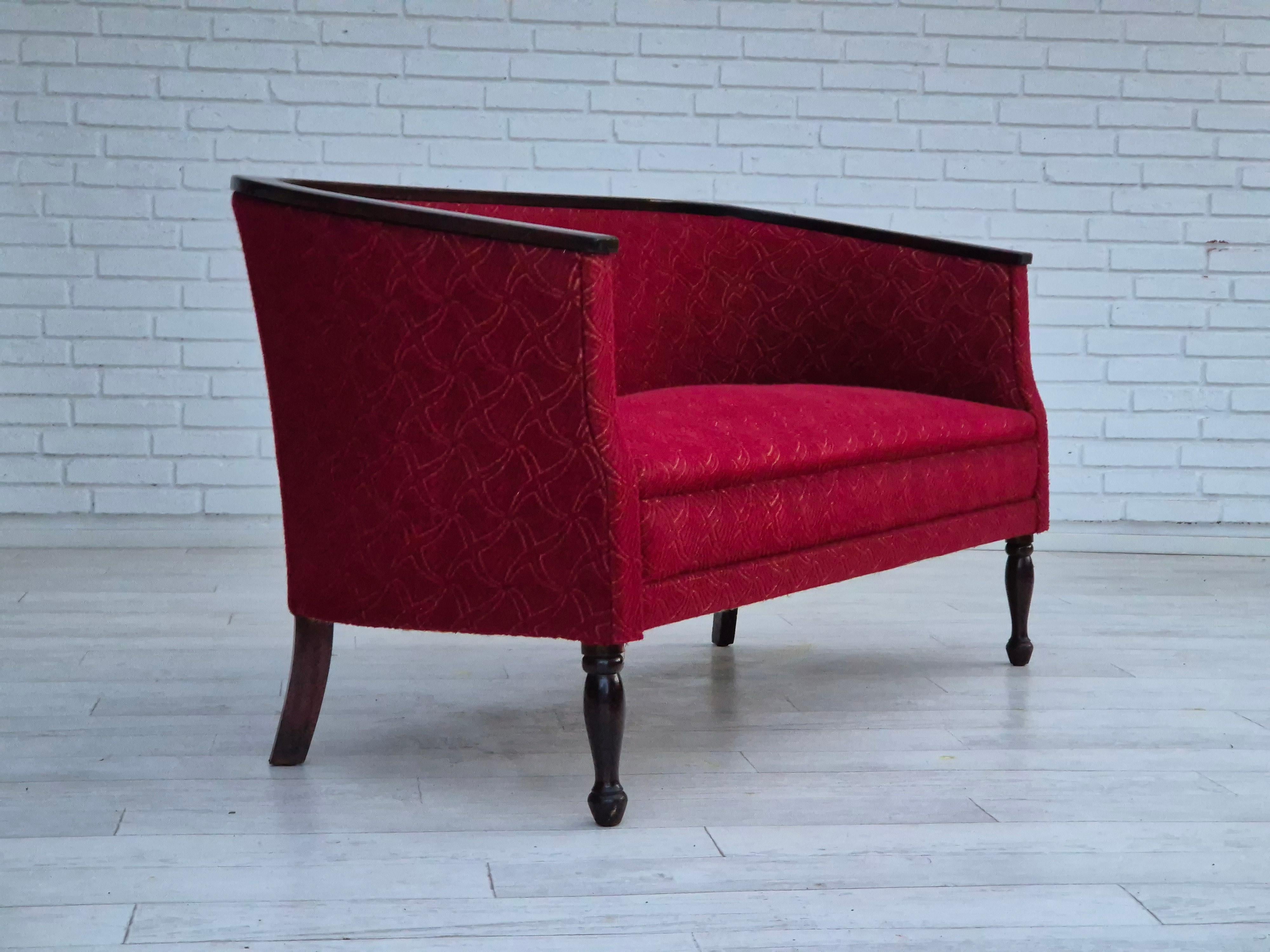 1950s, Danish 2 seater sofa in original very good condition: no smells and no stains. Red furniture fabric, dark lacquered ash wood legs and armrests. Brass springs in the seat. New springs belts under seat. Manufactured by Danish furniture