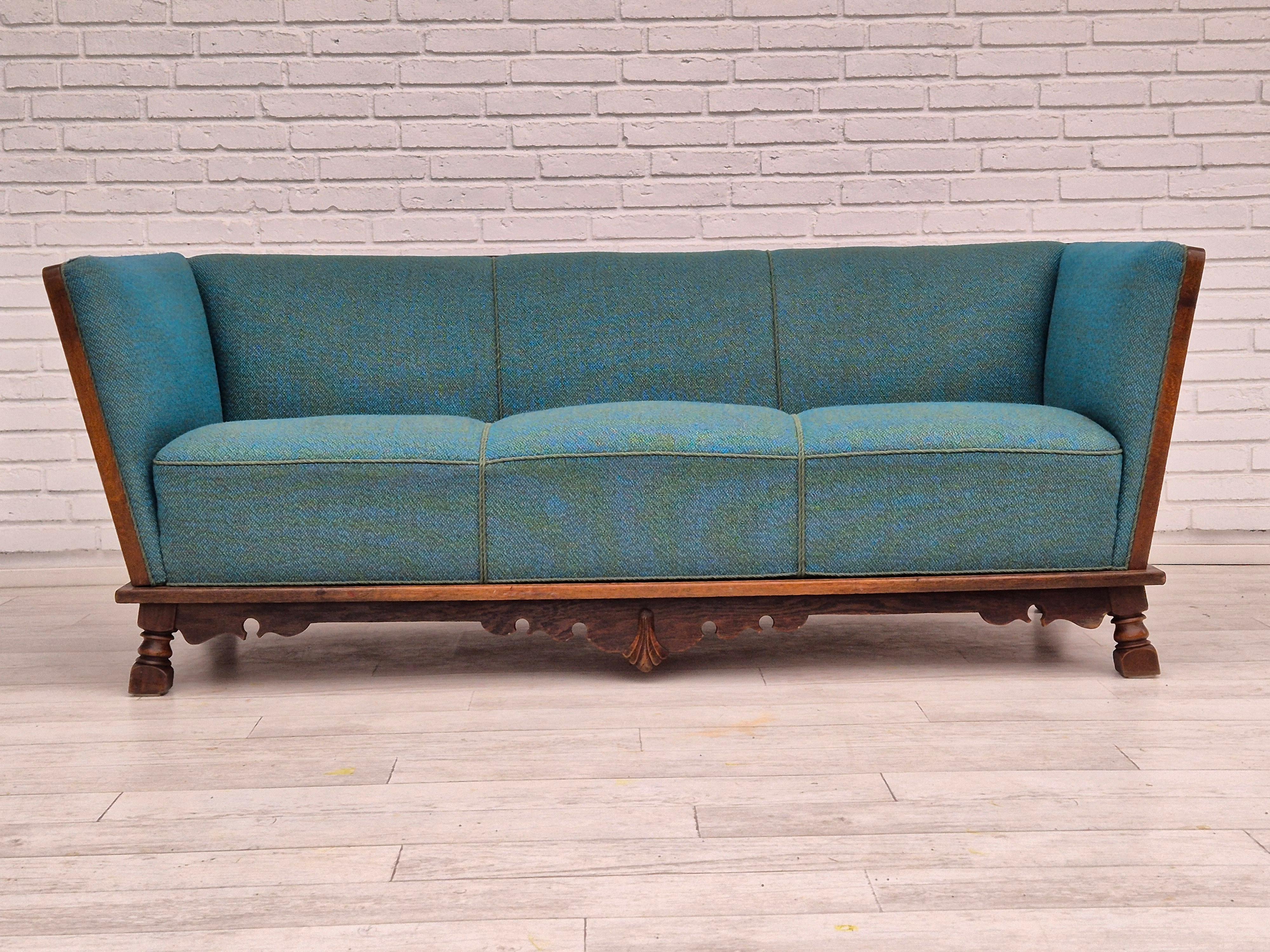1940-50s, Danish 3 seater drop arm sofa in very good condition: no smells and no stains. Sofa was reupholstered about 20 years ago by craftsman. Furniture wool fabric and dark oak wood. Drop arm on the one side. Springs in the seat. Manufactured by