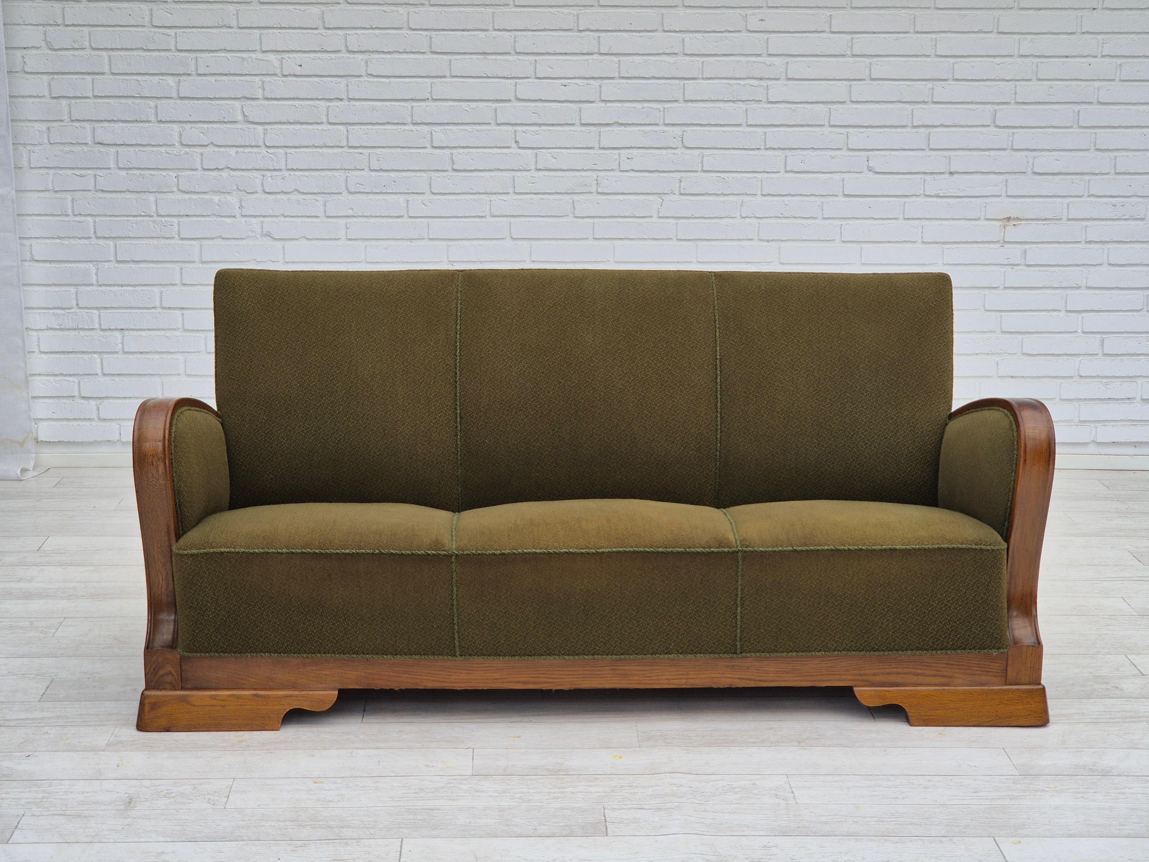 Canapé danois 3 places des années 1950 en très bon état d'origine : pas d'odeurs ni de taches, construction stable. Tissu d'ameublement original en laine/coton vert. Ressorts en laiton dans l'assise, pieds et accoudoirs en bois de chêne. Fabriqué