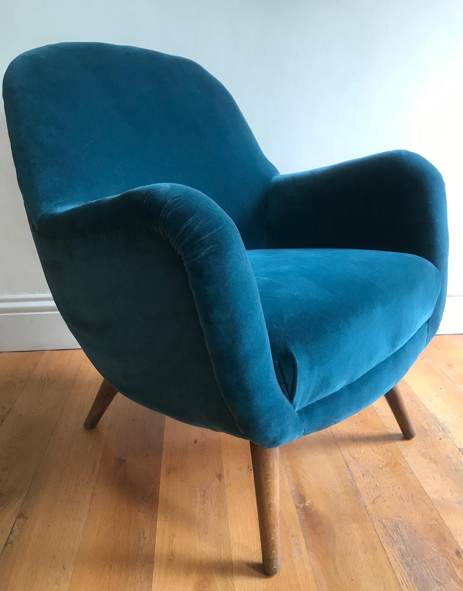 An original small 1950s Danish armchair reupholstered in teal colored velvet, resting on four cone shaped beech legs.