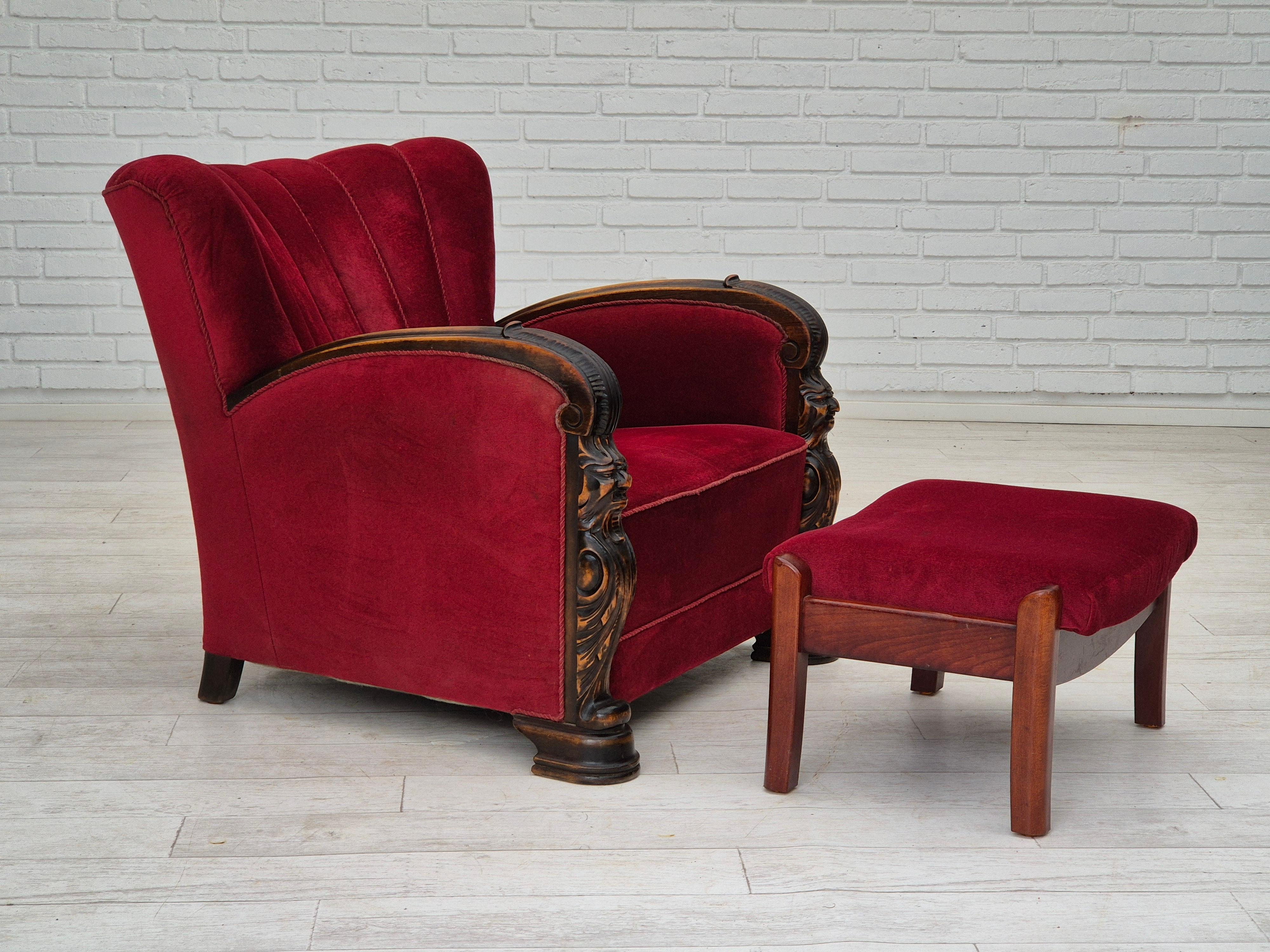 Años 50, sillón artesanal danés con reposapiés. La silla y el reposapiés fueron retapizados hace unos 20 años por un artesano. Muy buen estado: sin olores, sin manchas, construcción estable. Muebles de terciopelo rojo, reposabrazos tallados a mano