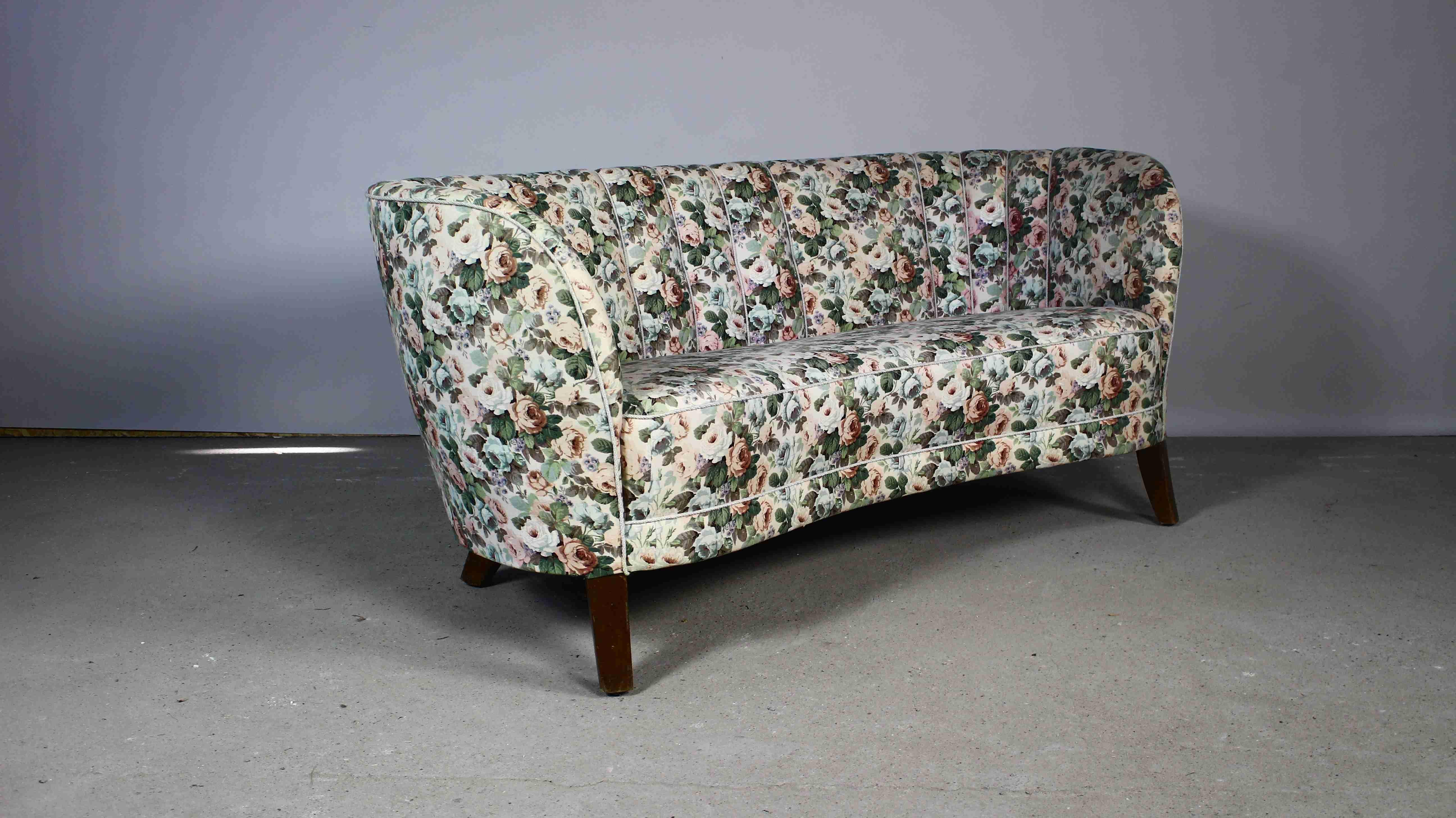 This early 1950s sofa is by Slagelse Mobelvaerk, made in the manner of Modernist Danish architect, Flemming Lassen.
The defined lines that characterize Danish design curve inward in this sofa, embracing the sitters.