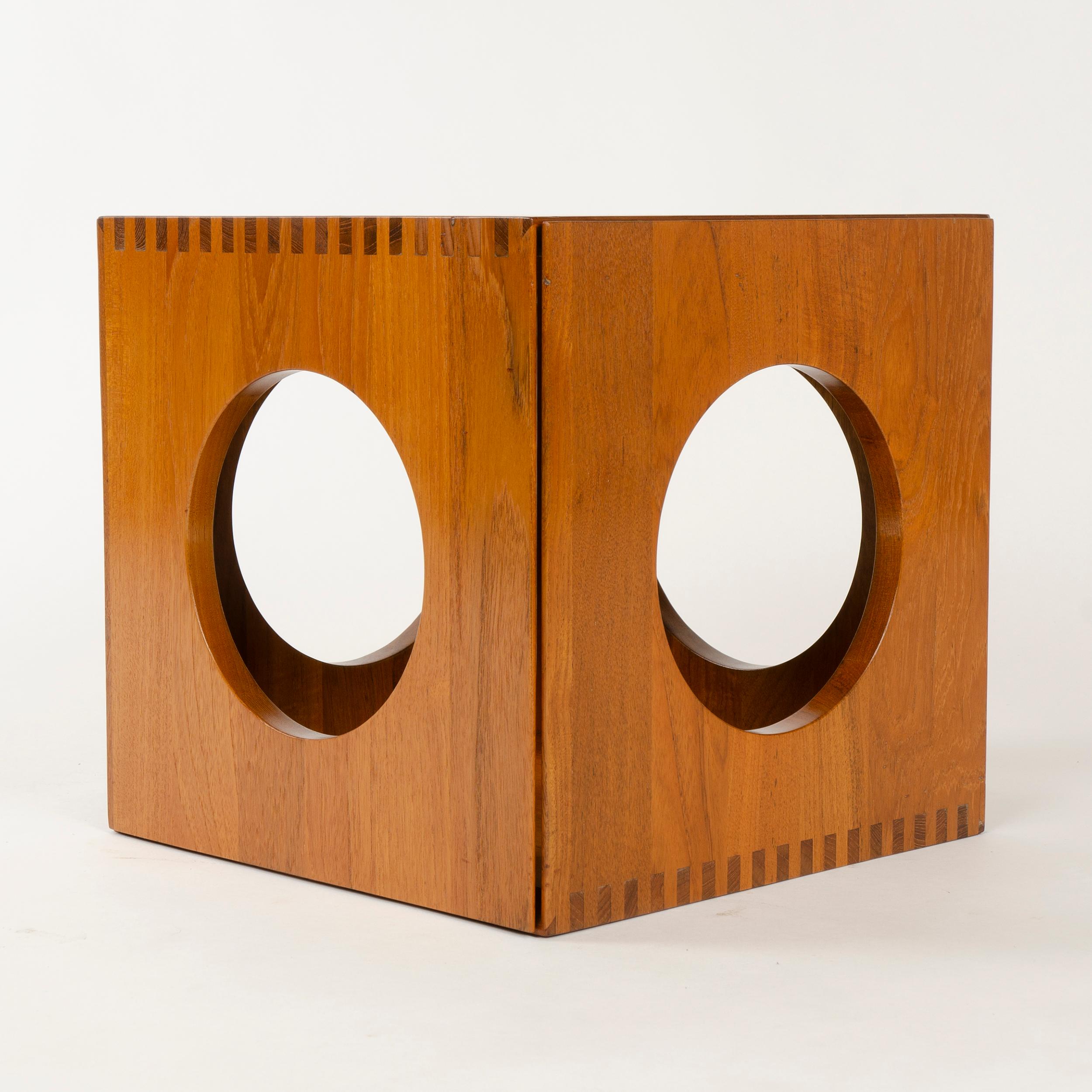 A pair of solid teak, finger-jointed end tables with round cutouts, which nest to form a cube.