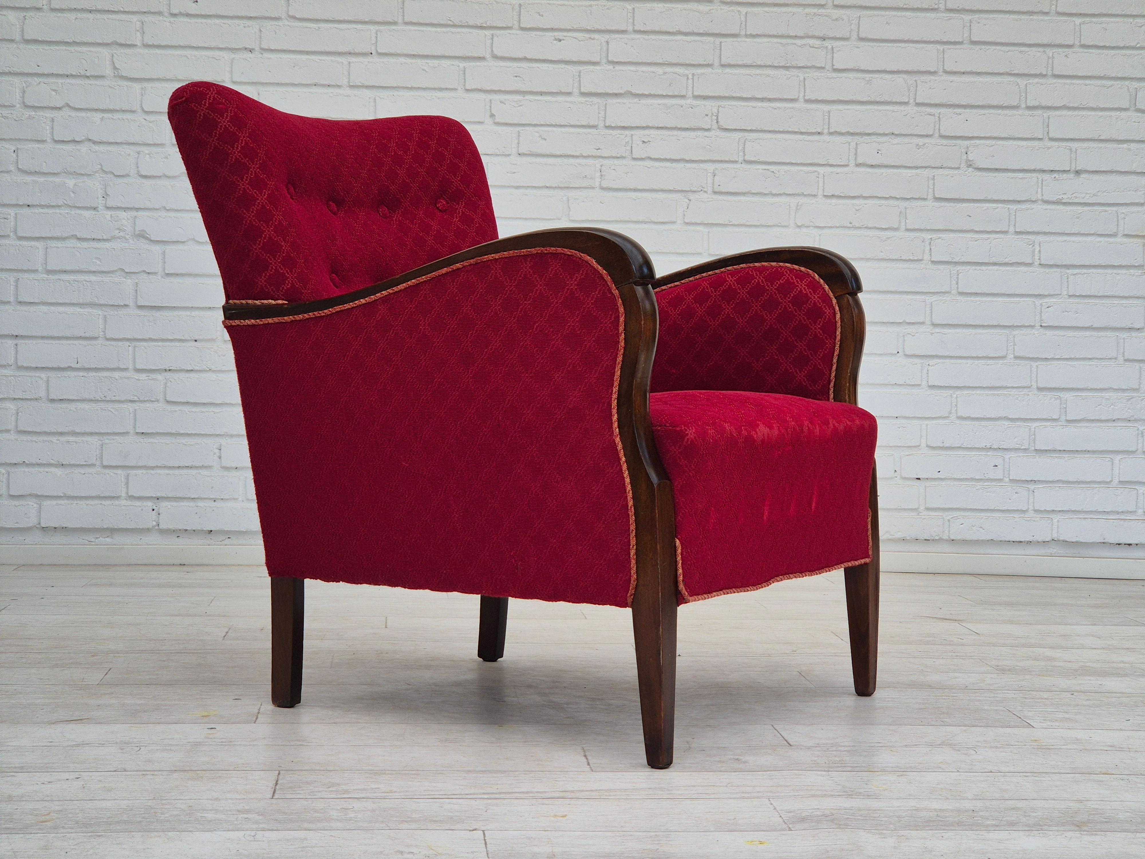 Années 1950, Design/One, fauteuil en bon état d'origine : pas d'odeurs ni de taches. Tissu coton-laine rouge d'origine, ressorts en laiton dans l'assise et le dossier. Pieds et accoudoirs en hêtre. Fabriqué par un fabricant de meubles danois vers