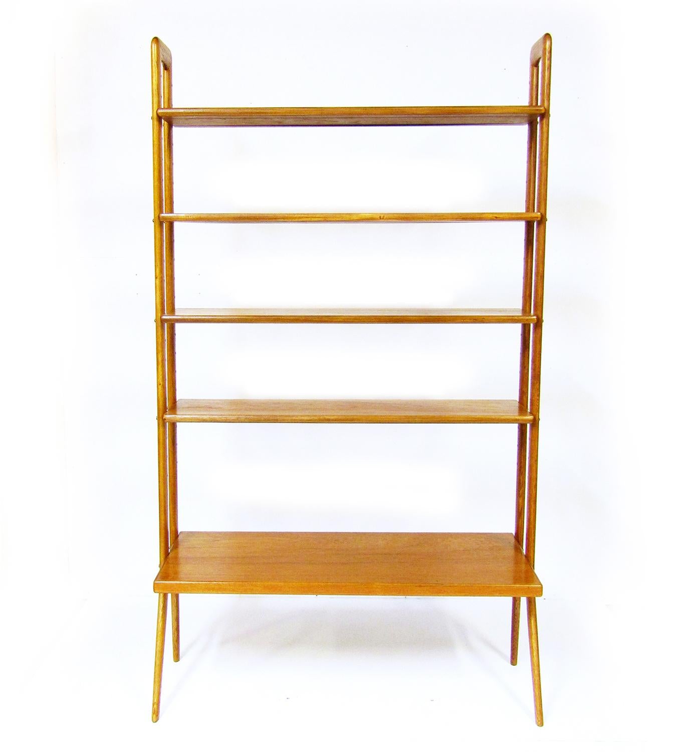 A 1950s Danish bookcase or room divider By Kurt Ostervig for International Designers Group.

The teak shelving contrasts with the oak supports, which are sculpted to angled, tapered legs, redolent of 1950s style.

It is fully adjustable. The