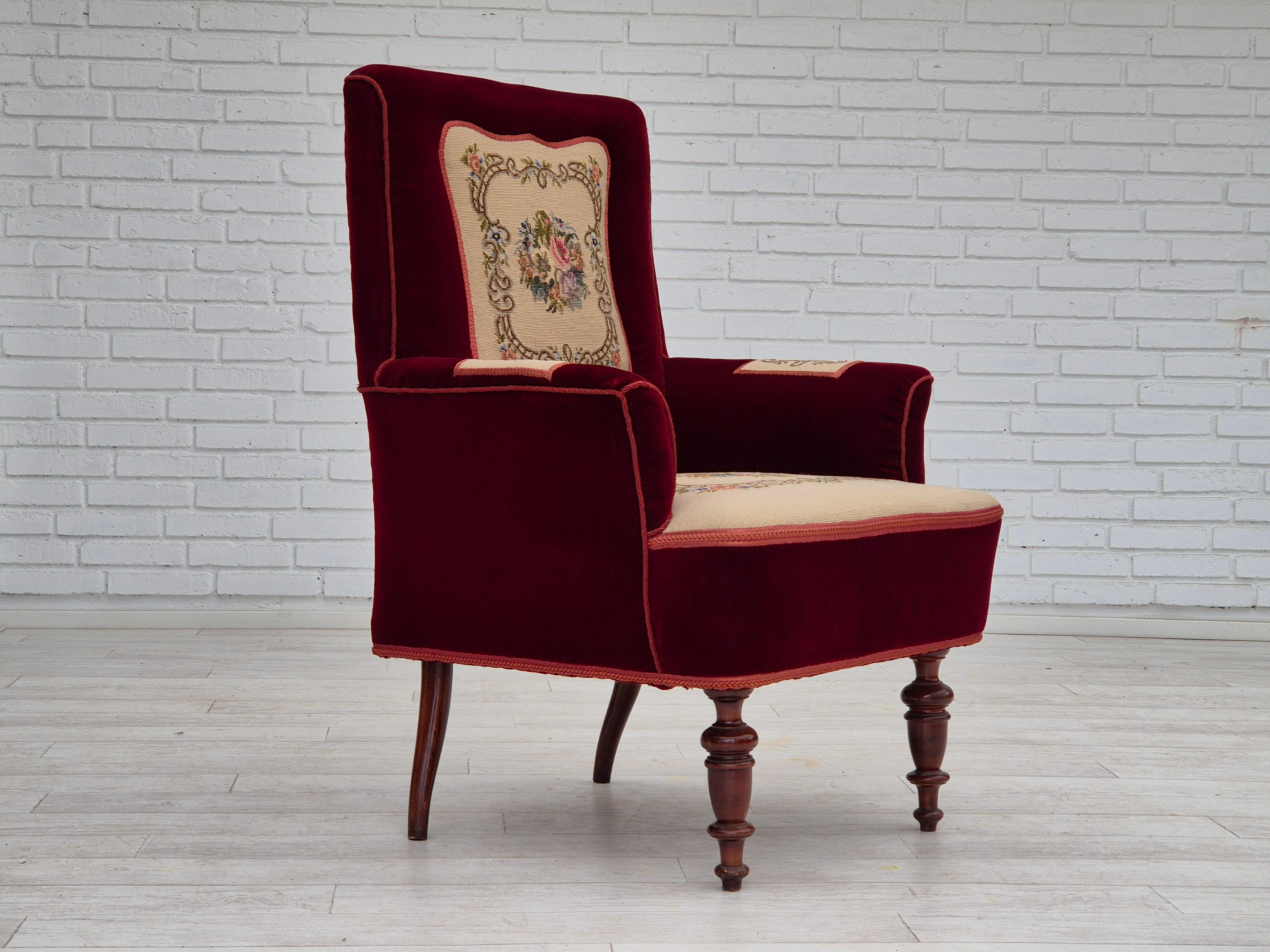 1950s, Danish handcrafted highback armchair in original very good condition. Cherry-red furniture velour with hand-sewn, woven patches in wool. Danish craftsmanship, probably from West Jutland. Beech wood legs, springs in the seat. Manufactured in