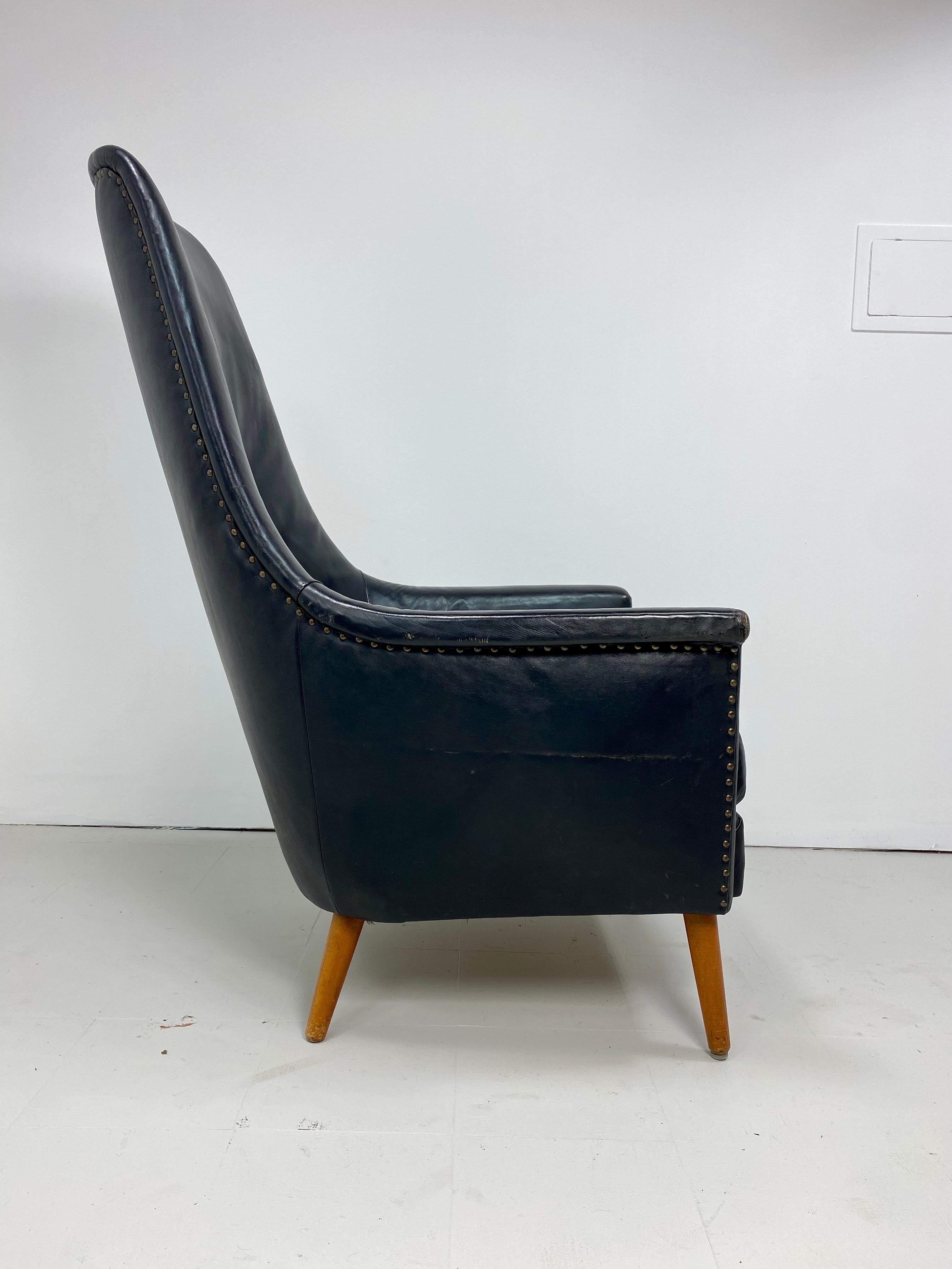Sculptural Danish Leather High Back Lounge Chair. Original black leather. Nailed head details. Beech wood legs. 1950’s. Denmark. 


