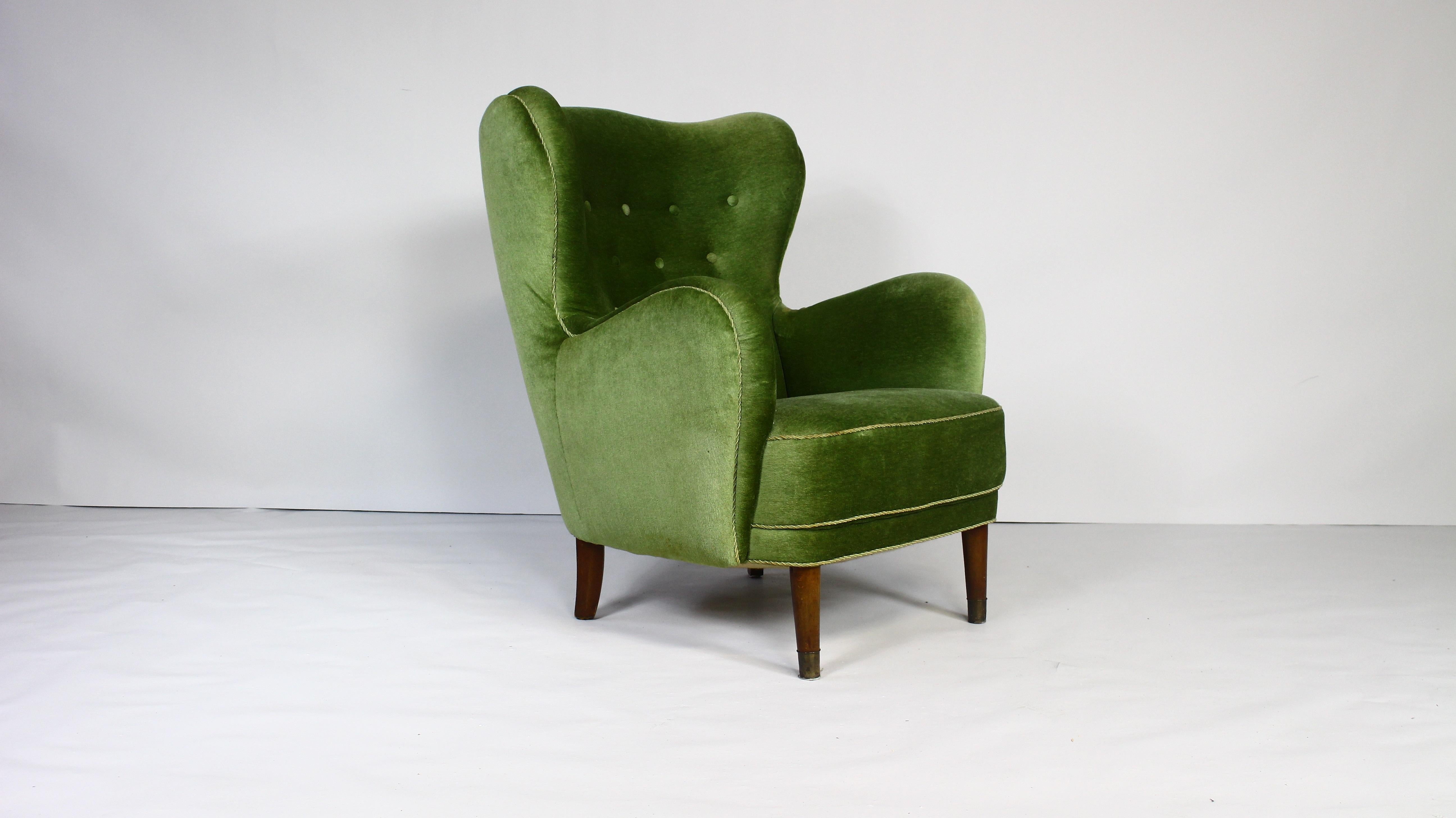 Lounge chair, stained beech, green velvet, Denmark, 1950s.

This archetypical wingback chair of the 1950s is both extremely comfortable and pleasing to the eyes.
 This easy chair with stained beech legs features a modest wing and buttoned back.