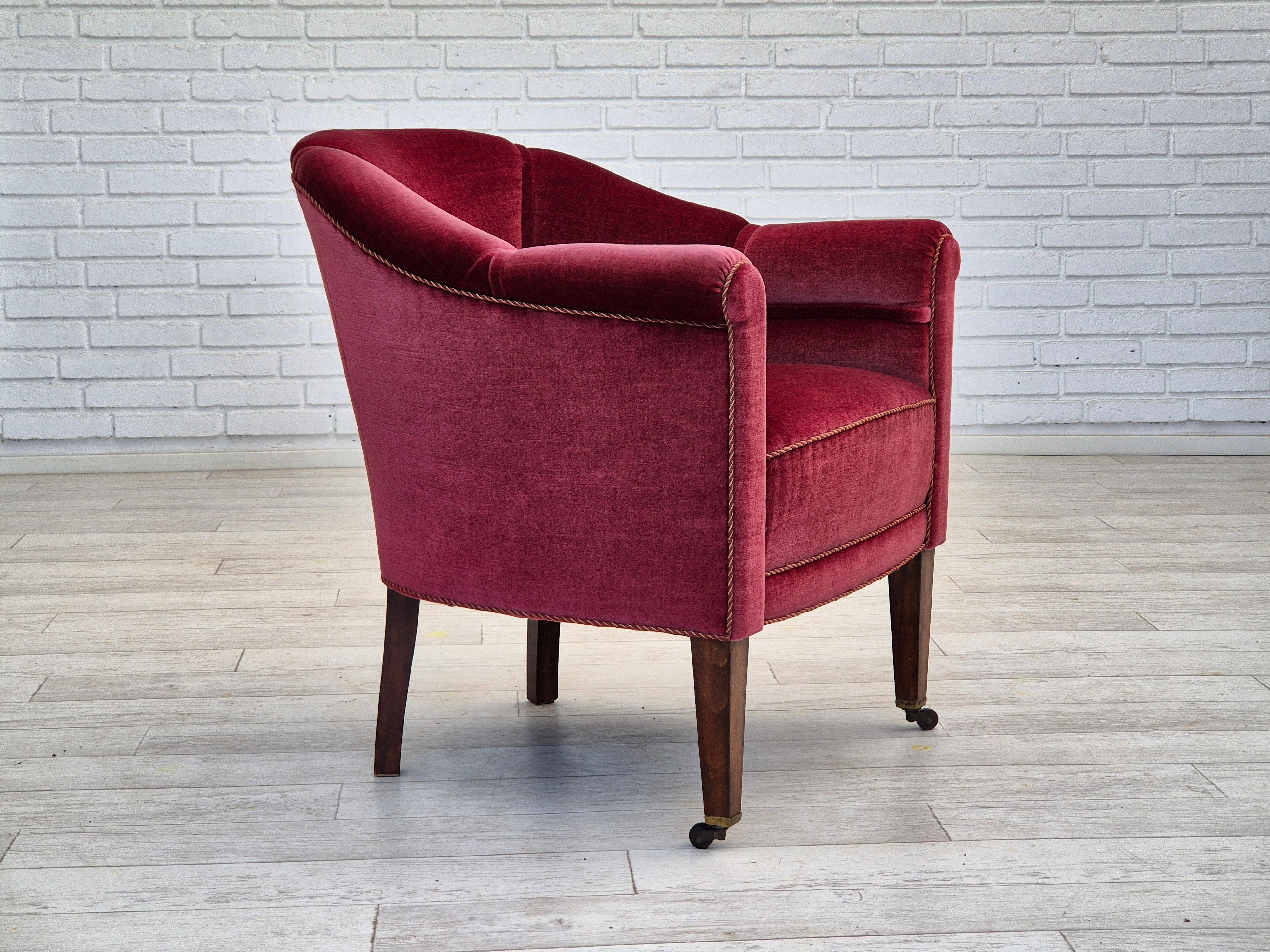 1950s, Danish lounge chair in original very good condition: no smells and no stains. Red furniture velour, ash wood legs with brass wheels on the front legs. Springs in the seat. Manufactured by Danish furniture manufacturer in about 1950-55s.