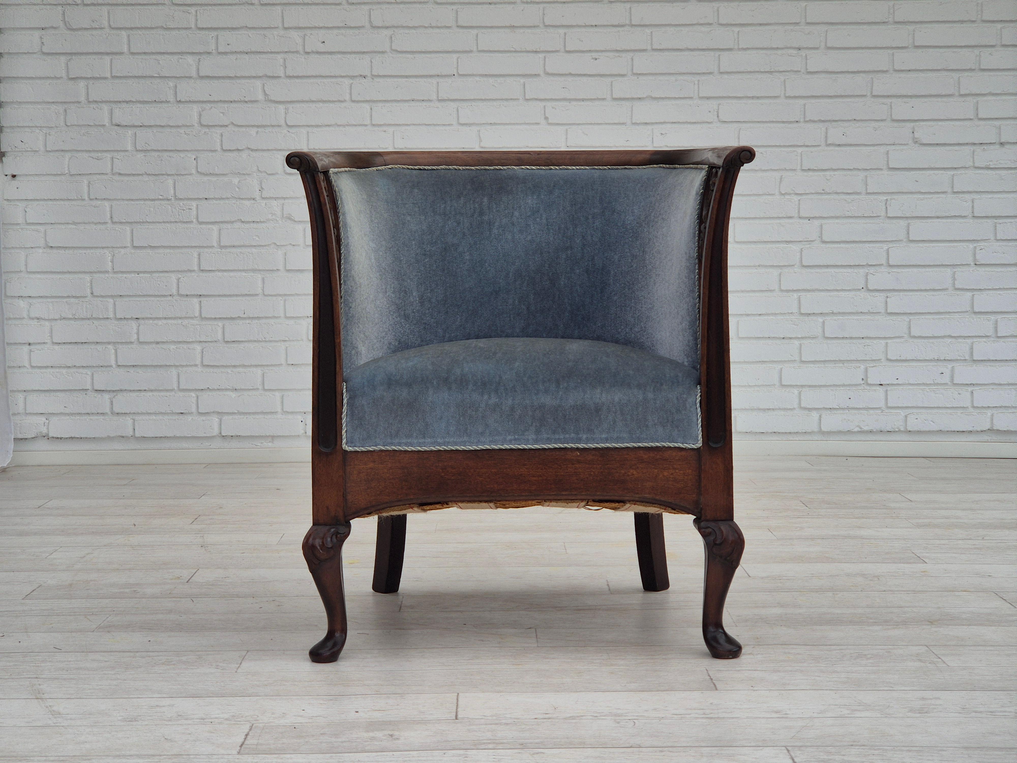 1950s, Danish design. Lounge chair in original very good condition: no smells and no stains. Hand-carved armrests. Original light blue furniture velour. Mahogany wood, brass springs in the seat. Manufactured by Danish furniture manufacturer in about