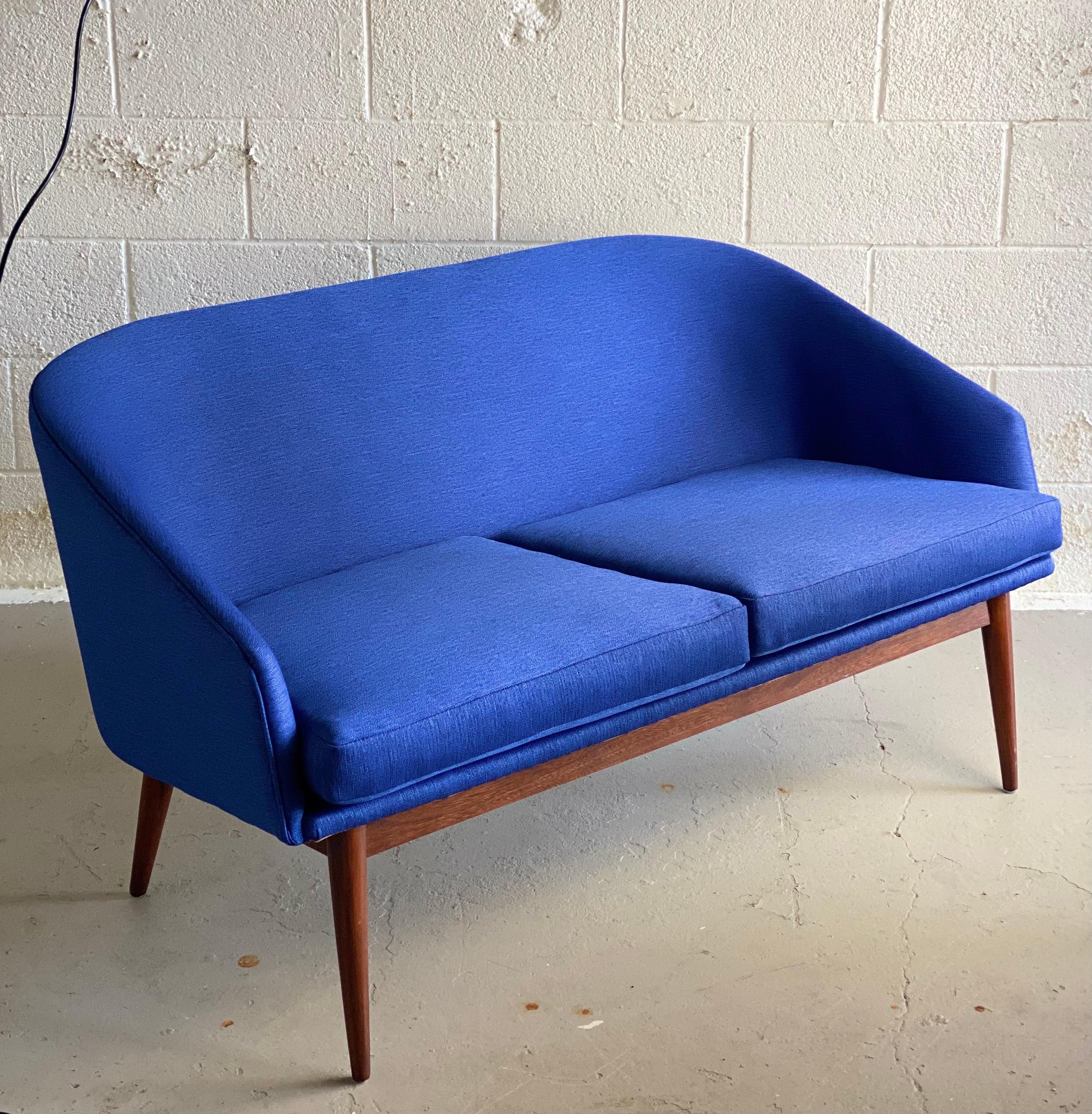 We are very pleased to offer a stunning, Danish modern sofa in the style of Arne Vodder, circa the 1950s. This beautiful piece has been meticulously restored by our expert craftsmen, keeping its original standards of aesthetics and composition to