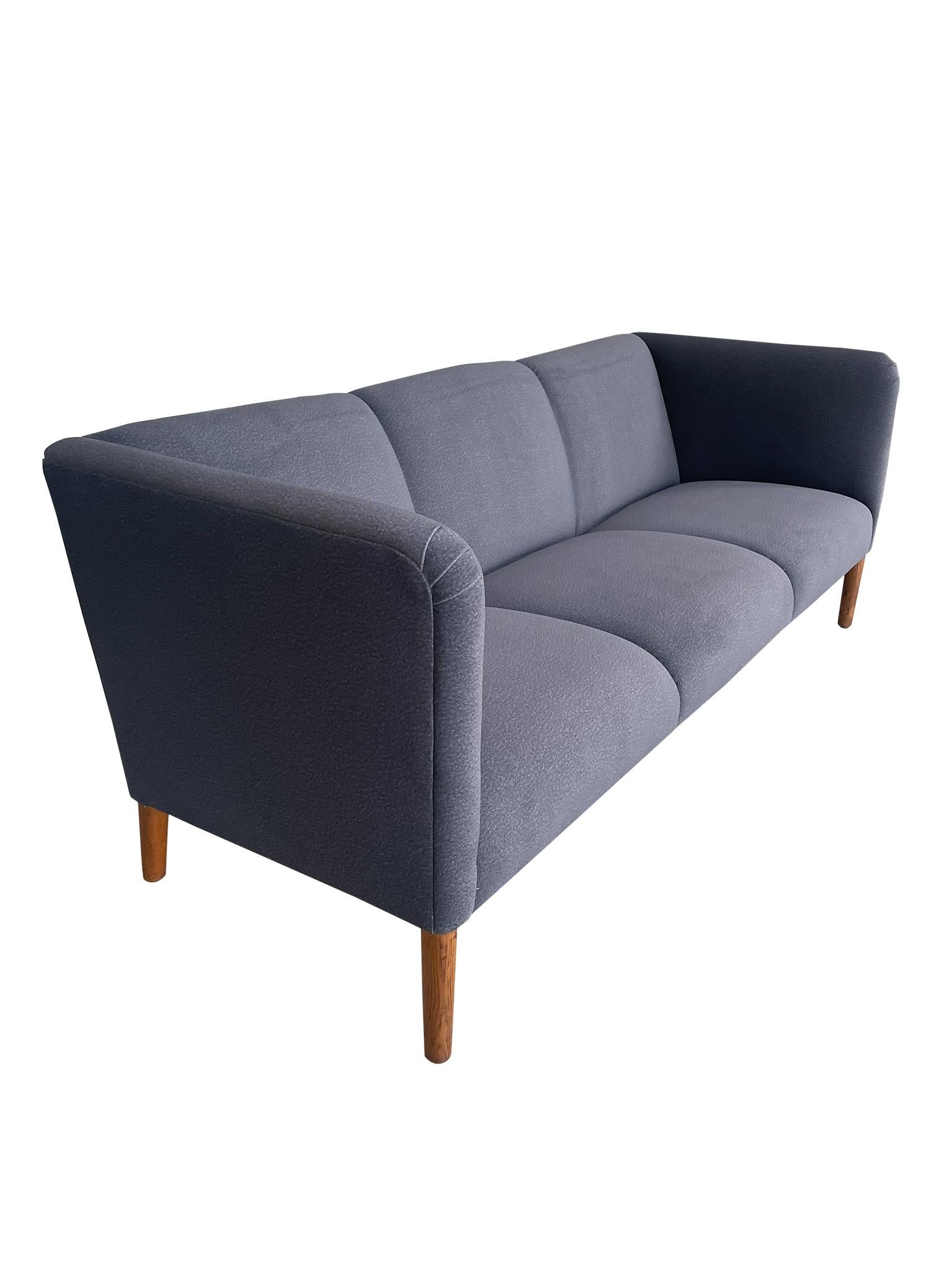 Wunderschönes dänisches modernes Modell AP18 Sofa von Hans Wegner, dem berühmten Möbeldesigner der Jahrhundertmitte, für AP Stolen. Das Modell AP18 Sofa zeichnet sich durch sein schlankes Profil, die drei Sitzplätze und die leicht zurückgelehnte
