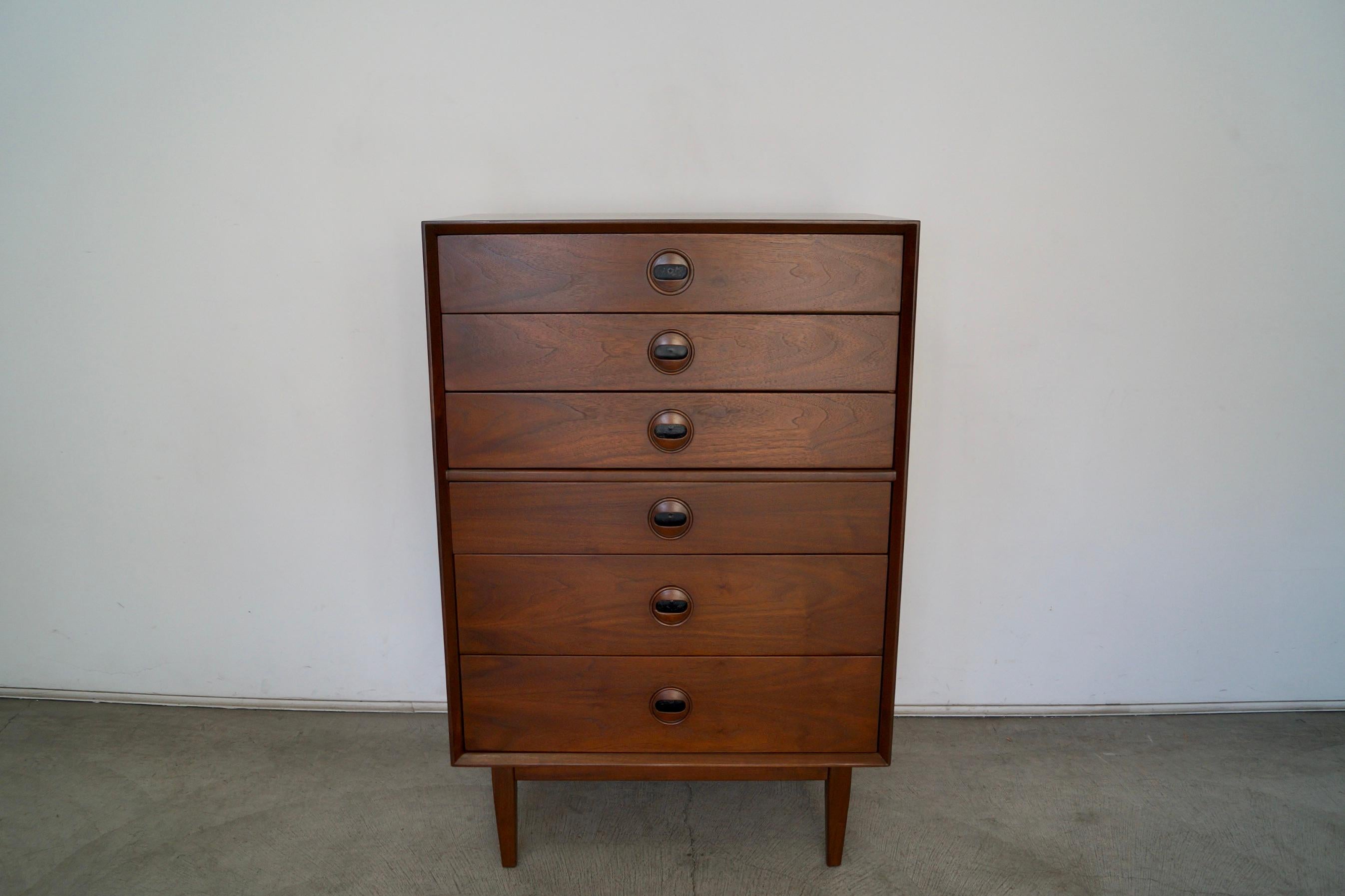 Vintage 1960s Mid-Century Modern highboy dresser for sale. Original Danish Modern dresser in walnut, and has been professionally refinished. It has six drawers dovetailed on both ends. It has solid walnut recessed handles with a black interior