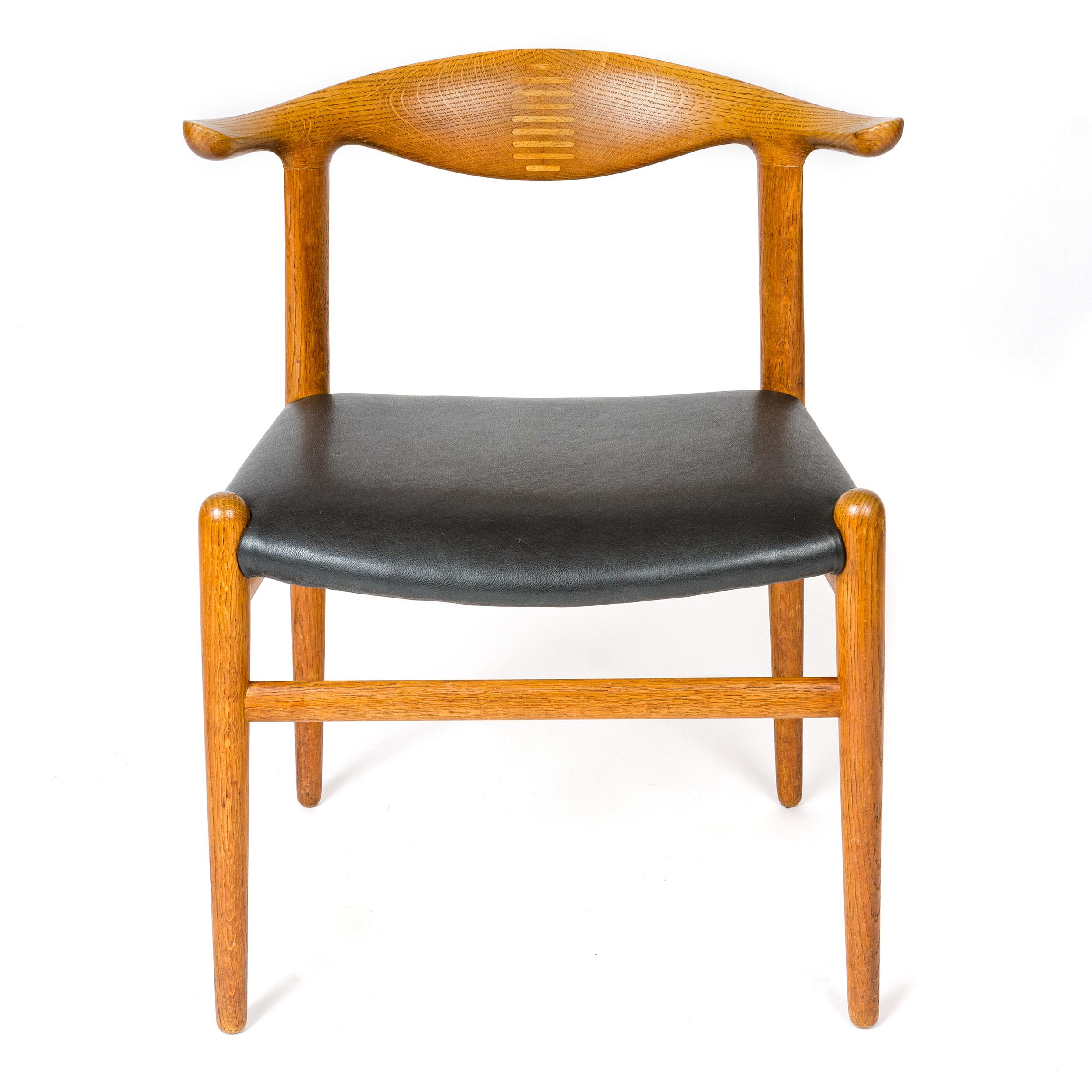 An uncommon oak 'cow horn' dining chair with a splined backrest and an upholstered leather seat. Model JH-505.