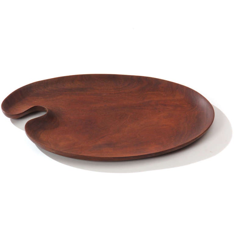 A sculpted hand formed teak tray in the shape of an artist's palette.