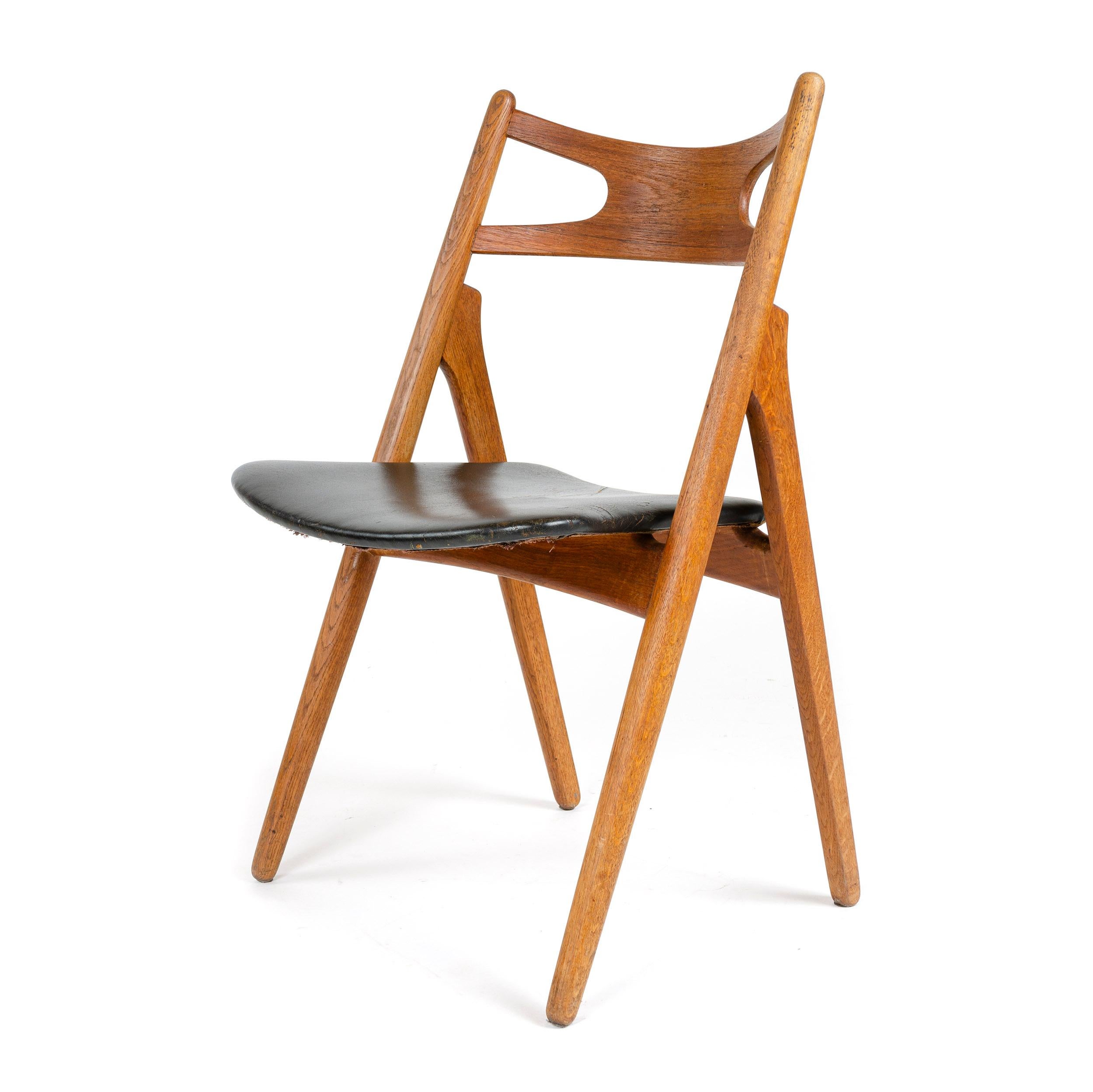 An oak 'Sawbuck' dining/desk chair with a black leather seat.