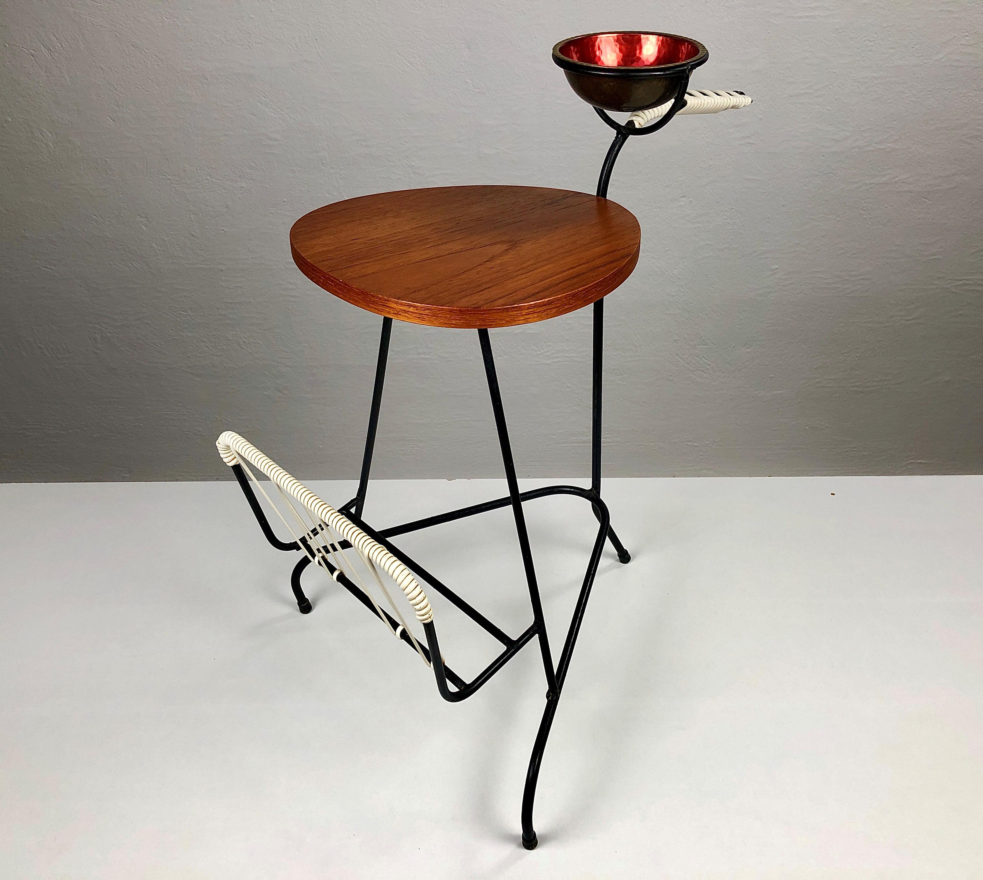 Kleiner dänischer Beistelltisch - Tabletttisch aus Teakholz und schwarzem Metall aus den 1950-1960er Jahren.

Der Tisch bietet alles, was man für eine kleine Pause braucht: eine kleine Tischplatte aus Teakholz für eine Tasse Kaffee oder ein Getränk