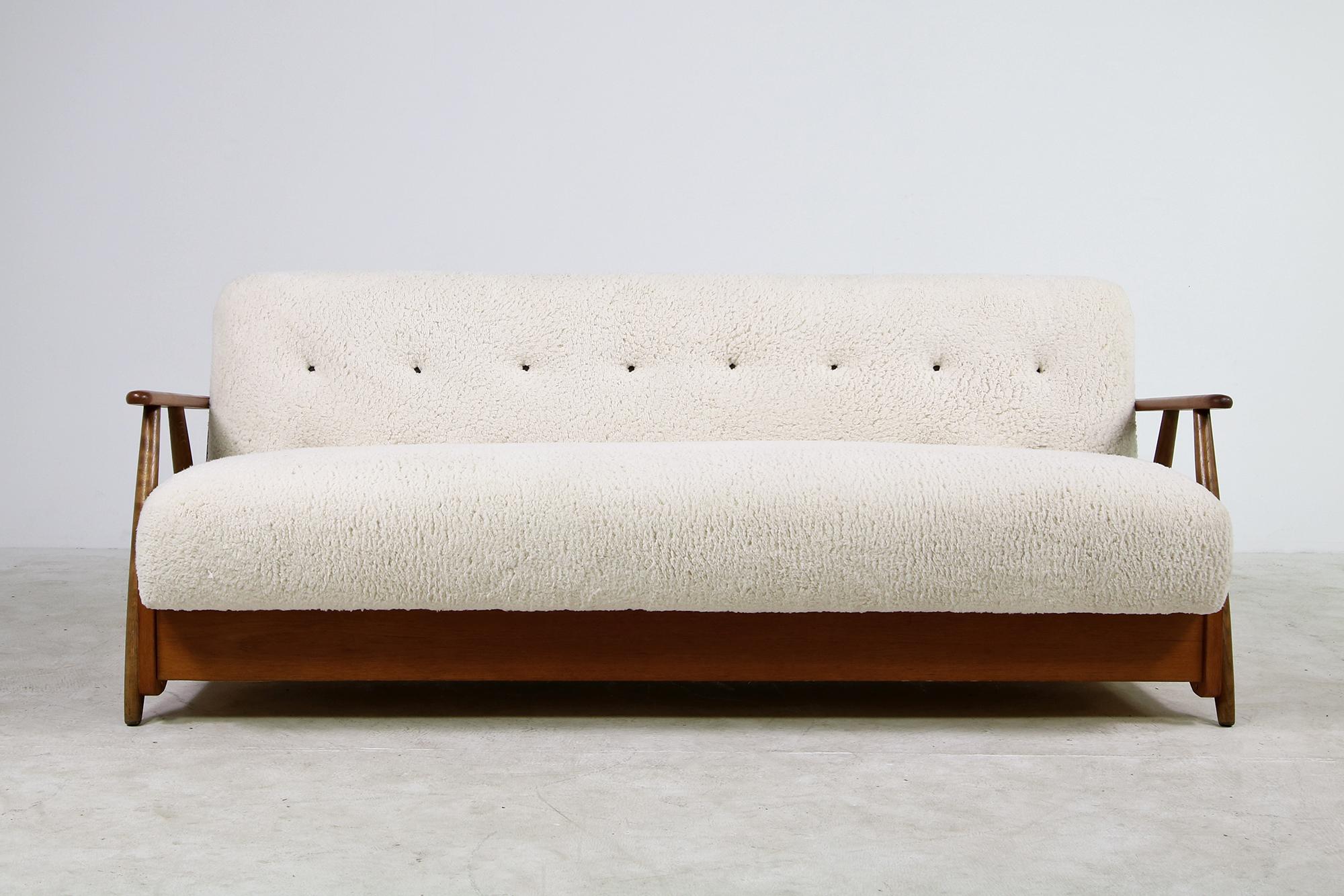 Beautiful authentic midcentury sofa. from the early 1950s made in Denmark, reupholstered, covered with great teddy fur fabric, like sheepskin, but softer to the touch, super cozy, tufted with brown leather buttons, the sofa has beechwood legs and