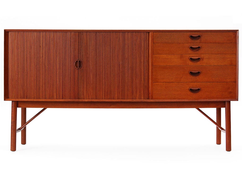 An asymmetrical solid teak credenza by Peter Hvidt and Mølgaard-Nielsen. Features tambour doors and five drawers.