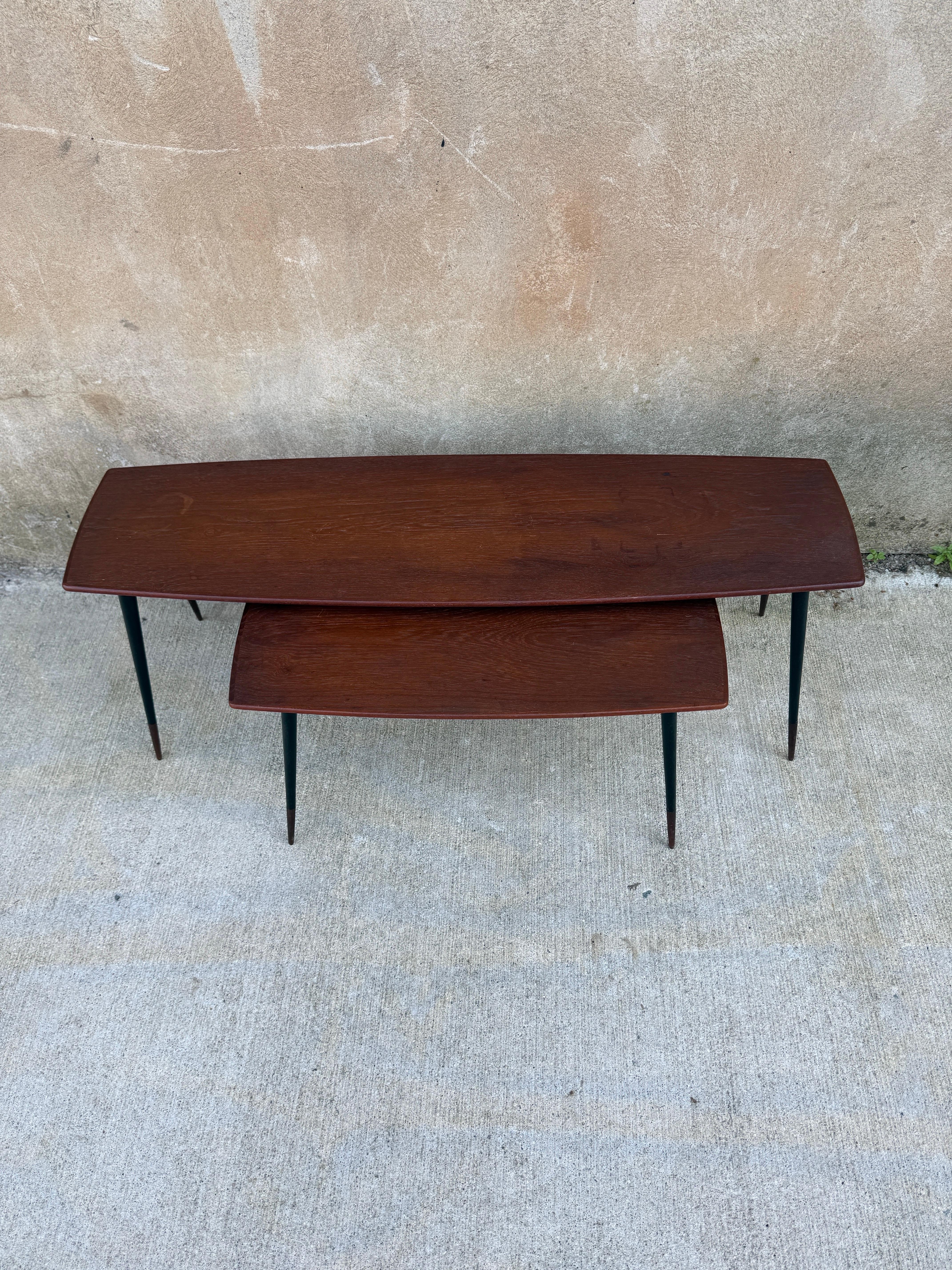Magnifique ensemble de tables gigognes danoises en teck des années 1950 avec de remarquables pieds évasés en teck.  Estampillé Holm Sorensen sur toutes les bases métalliques, et autocollants en papier de contrôle danois sur la face inférieure du