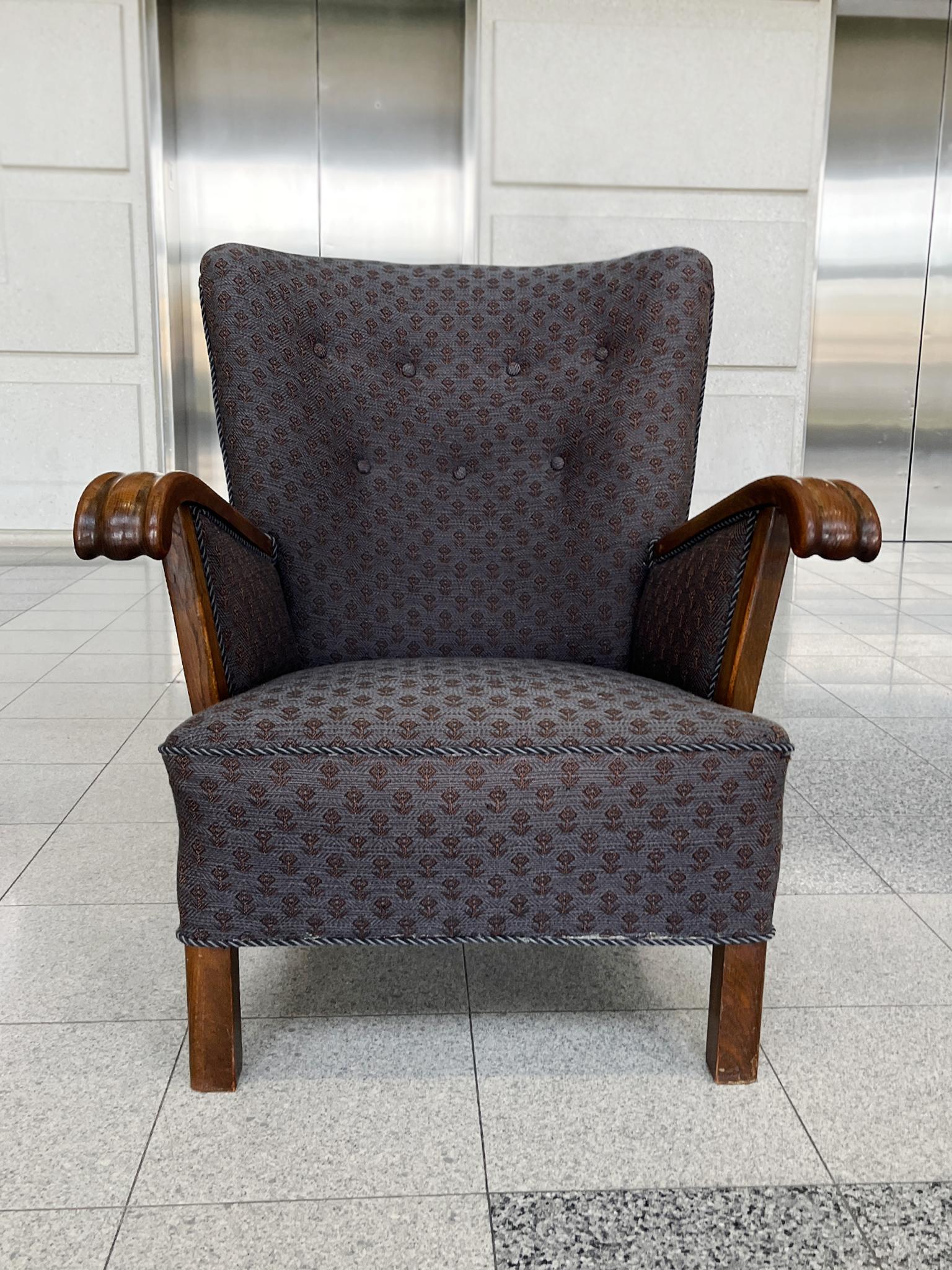 Fabriqué dans les années 1950, ce fauteuil danois à dossier ailé reprend les élégantes créations d'Alfred Christensen, fondateur de Slagelse Møbelværk. Le cadre, les accoudoirs et les pieds sont en acajou, tandis que le revêtement est un tissu tissé