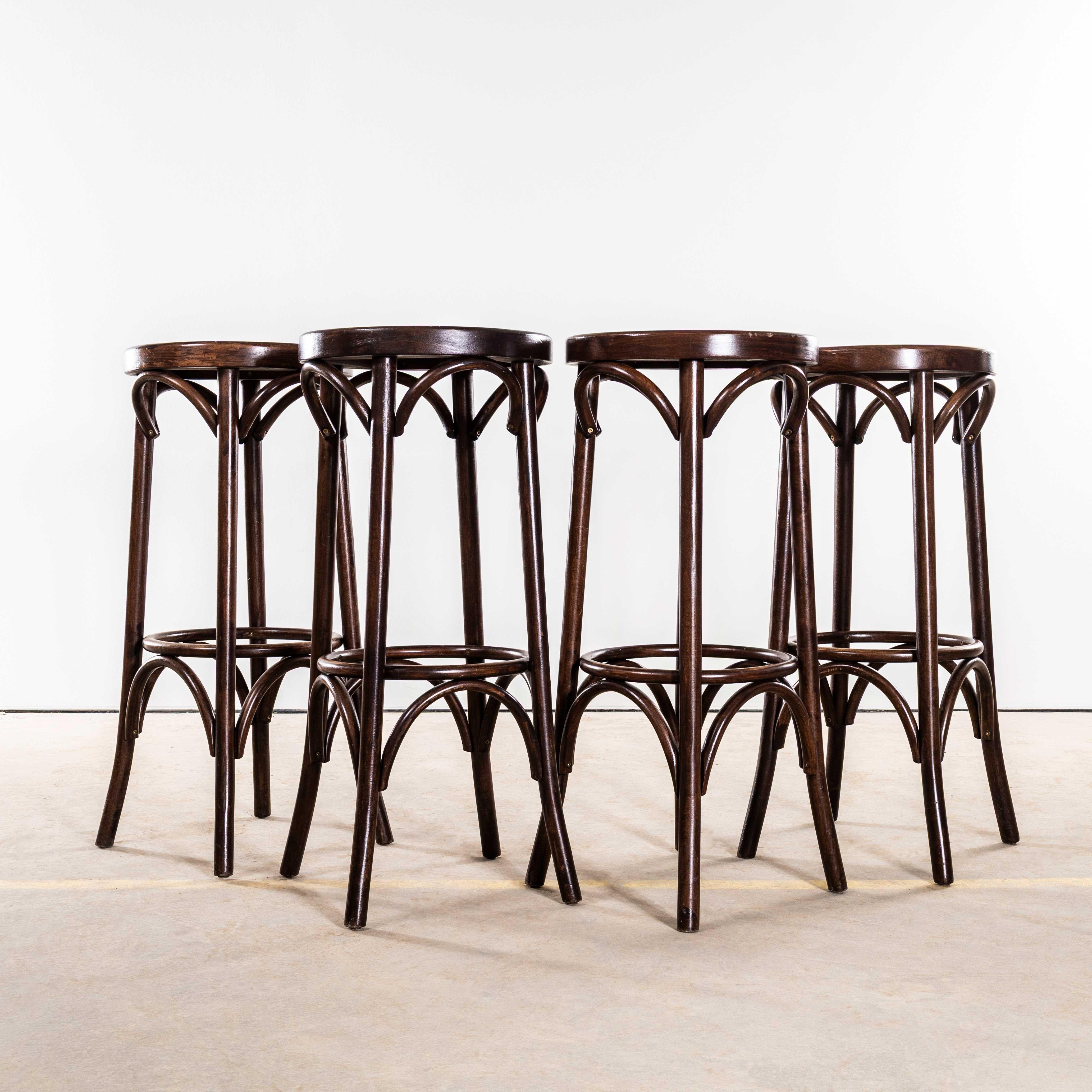 Taburetes de bar de madera curvada de roble oscuro de los años 50 - Juego de cuatro. 
Taburetes de bar clásicos de madera curvada de buena calidad con un intenso color roble oscuro y diseño clásico. Los taburetes se fabricaron en Europa del Este