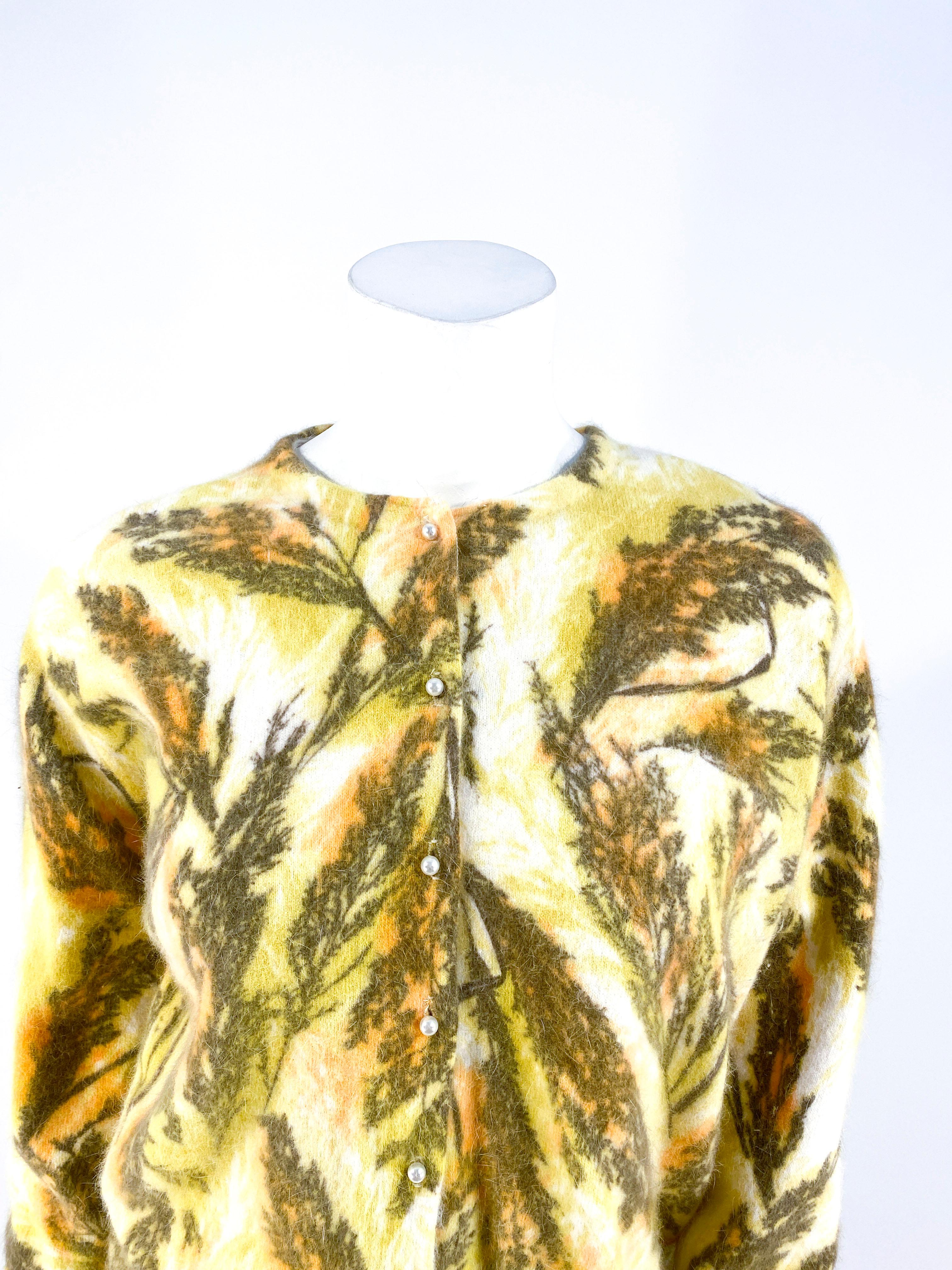 1950's Darlene printed angora/ lambswool printed cardigan featuring a foliage motif print in autumn tones of apricot, gold, cream, and olive. The face has a button down pearl closure that ends at the ribbed hem. The knit angora/lambswool is very