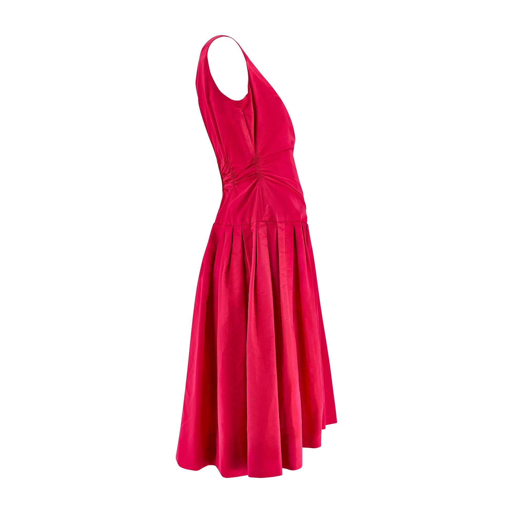 Cette robe de la fin des années 1950 est signée De Pinna et est confectionnée dans un taffetas de soie rose fuchsia mat incroyablement vibrant. Réalisé pour la boutique de la marque sur la Cinquième Avenue, à New York, il est entièrement doublé de