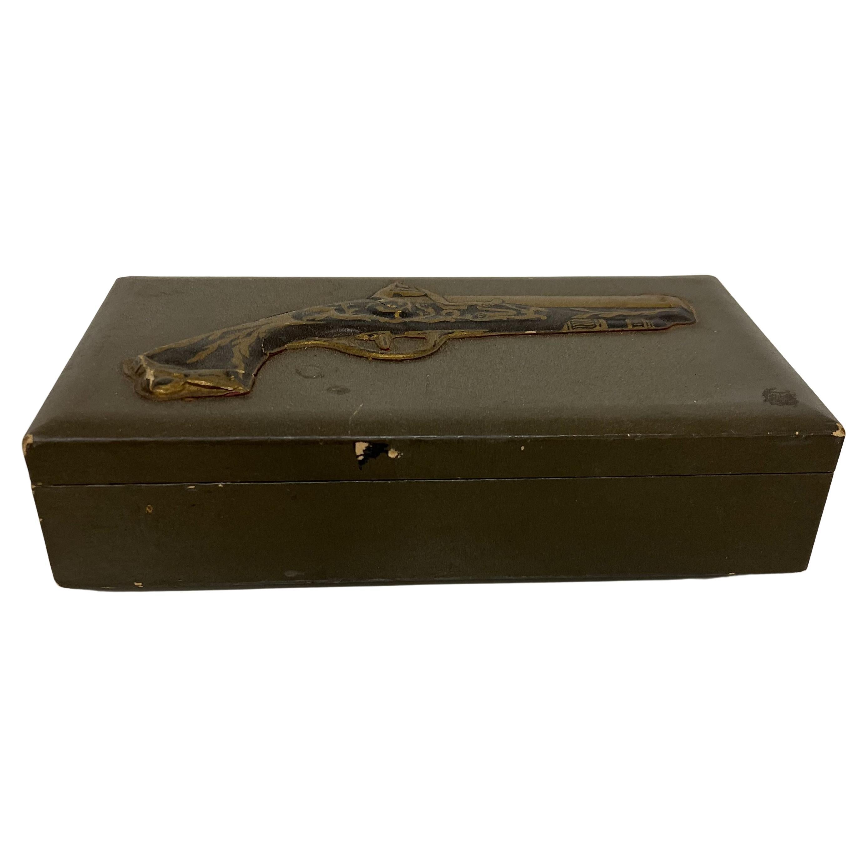 Old box with interior compartments, possibly to store jewelry.
Image of gun on top.
Inside one piece of paper to hold something is broken
2.75 tall x 11 w x 6.25 d
Preowned unrestored vintage distressed condition.
See all images.