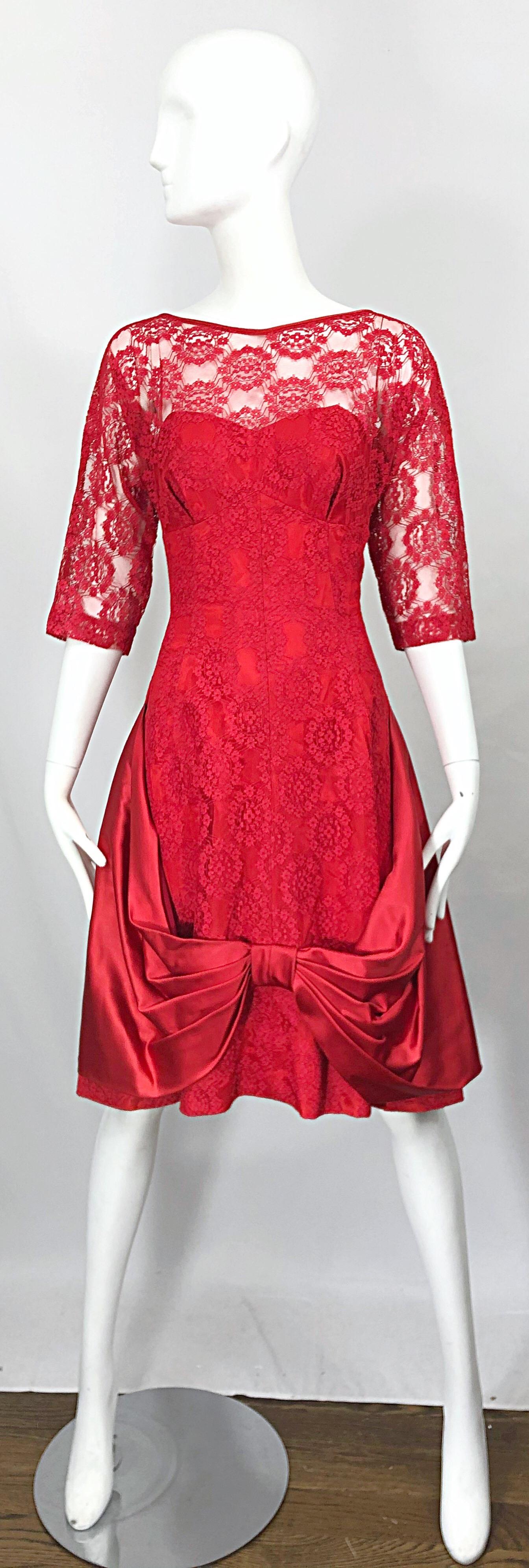 Incredible 1950s demi couture lipstick red silk lace fit n' flare cocktail dress! Features silk taffeta with red lace overlay. Large satin bow detail at center front hem. Fitted tailored bodice with a forgiving full skirt. Hidden metal zipper up the