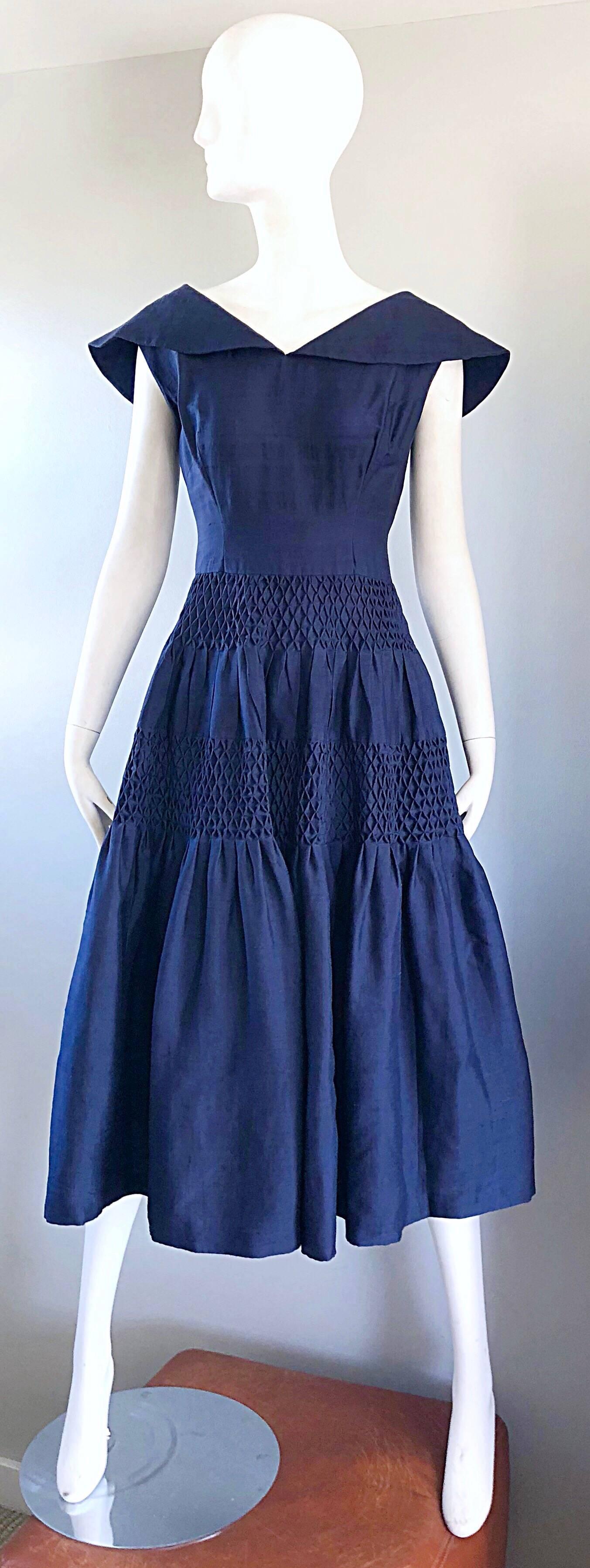 Gorgeous 1950s demi couture navy blue silk shantung nautical fit n' flare dress! Masterfully designed, with a very heavy attention to detail. Fitted bodice, with a forgiving and flattering full skirt. Shawl like collar, with ribbon bow detail on the
