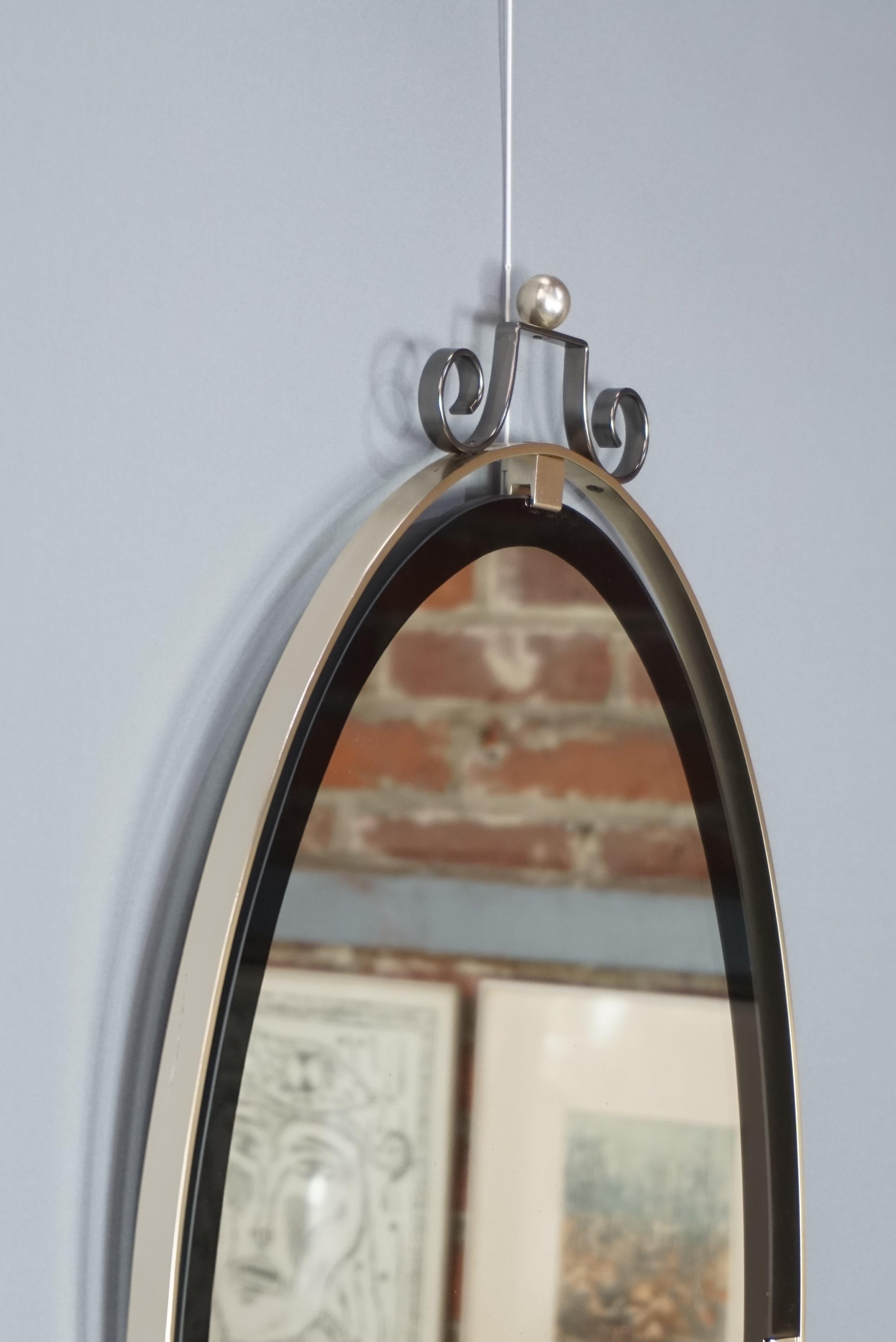 Oval and hanging mirror, French design of the 1950s with a black underlined outline and chromed metal structure. In excellent state of conservation. The dimensions of the mirror alone (excluding chrome structure) are 64cm, 40cm.
