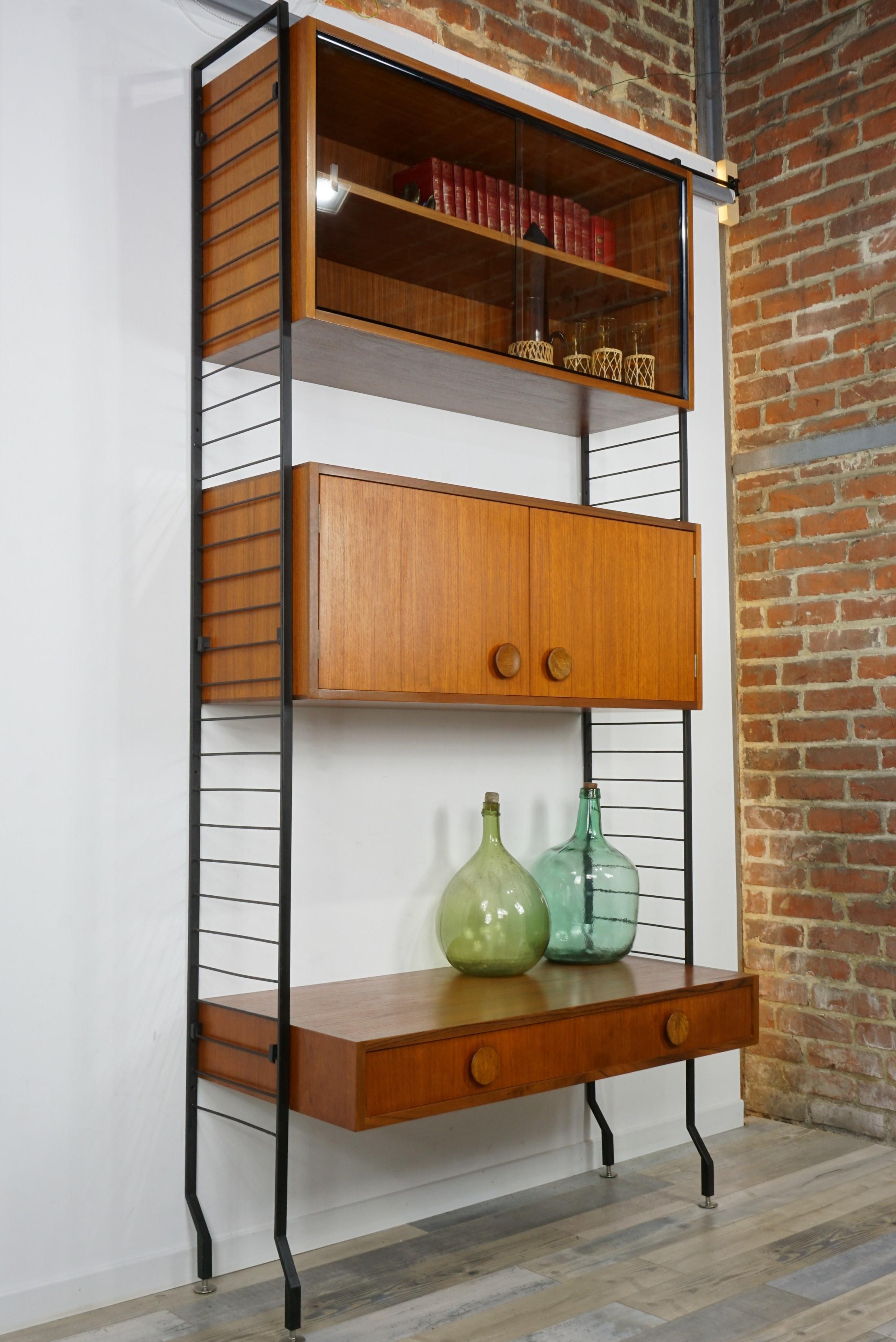 1950s design teak wooden and black metal wall unit shelves or cabinet composed of a black metal and airy wall mounted structure where you can put on 3 teak wooden storage cabinets: a vitrine, a cabinet and a desk for example! Practical, modular and