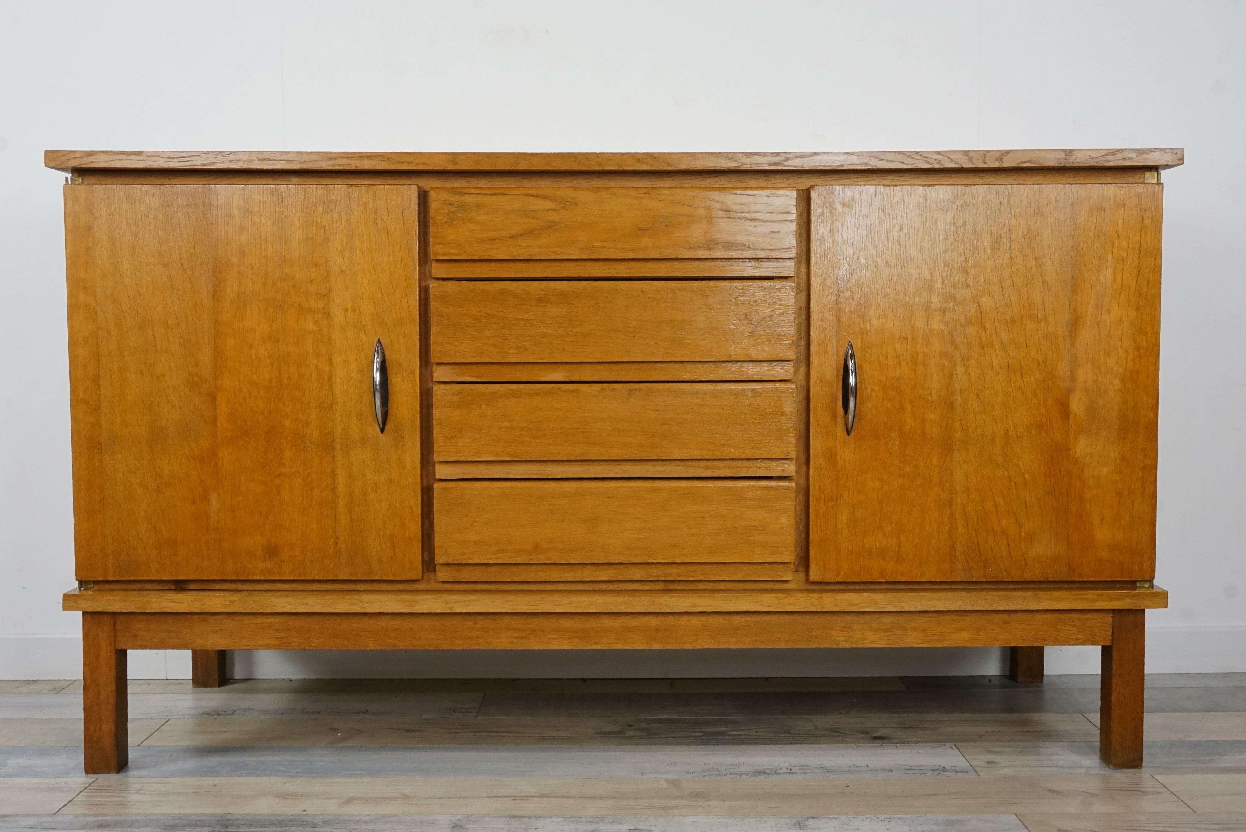 1950s sideboard with sober and Minimalist lines composed of a wooden structure with multiple storage spaces; doors on each side, chrome handles and 4 central drawers, all in perfect condition. Harmony and Organization!