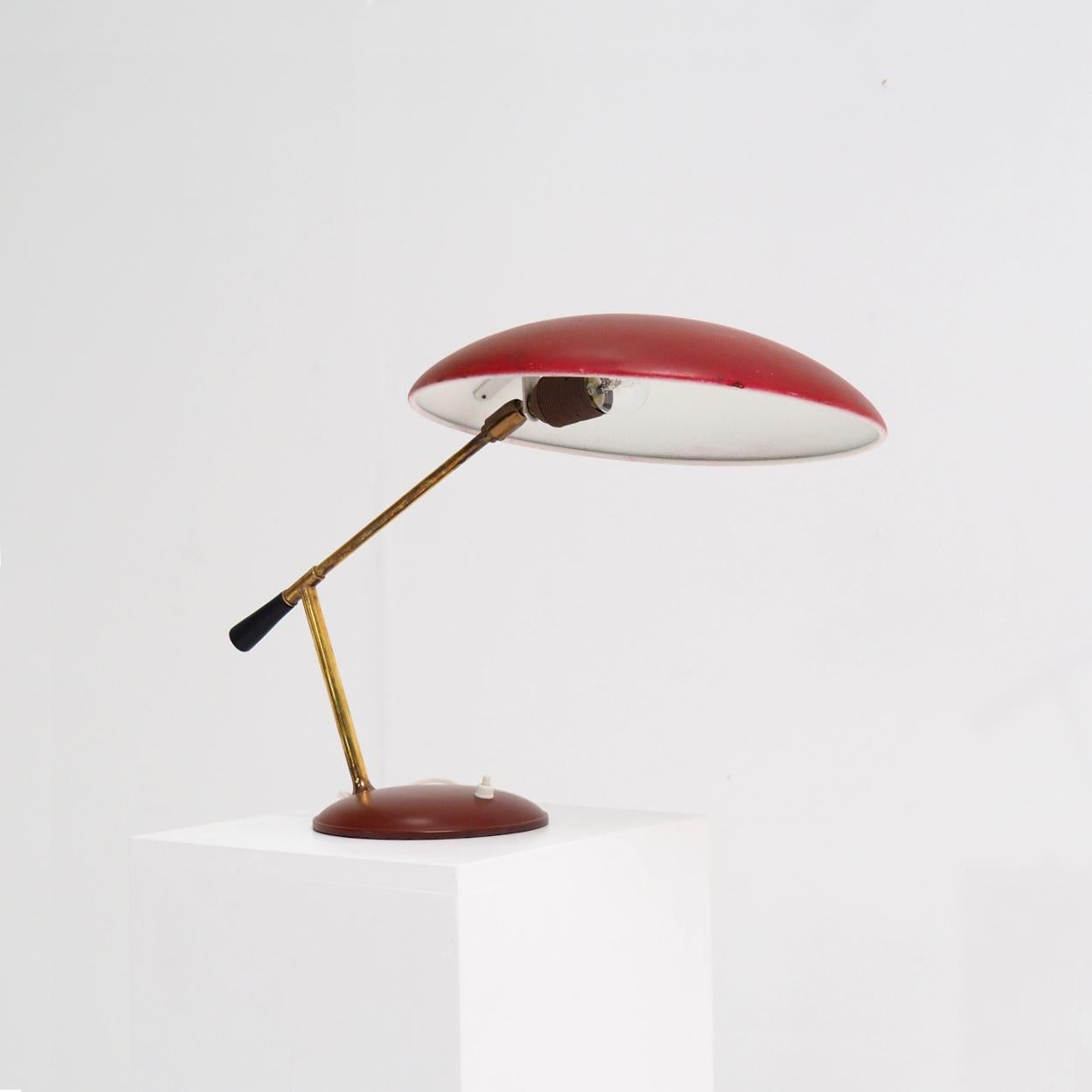 Diese Tischleuchte aus den 1950er Jahren, deren Designer und Hersteller unbekannt sind, ist stark von italienischen Designs aus der Mitte des Jahrhunderts inspiriert. 

Die Leuchte besteht aus Kupfer in Kombination mit burgunderrot lackiertem