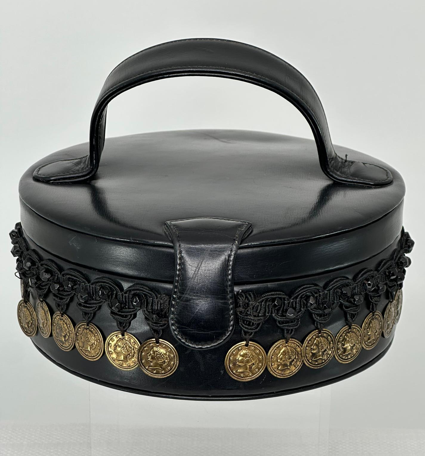 Borsa vintage Deutz degli anni '50 in pelle nera con manico superiore, monete d'oro e perline. Divertente borsetta che assomiglia a una piccola cappelliera. Borsa con manico superiore e chiusura frontale a scatto rivestita in pelle. La borsa è