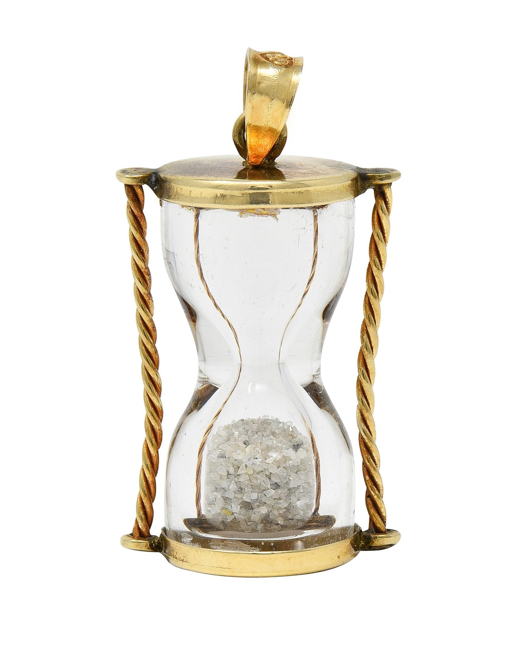 Progettato come una balla affusolata che sospende una clessidra di vetro.
Con colonne e terminali in corda ritorta in oro giallo
Caratterizzato da diamante frantumato come sabbia
Durata di circa 2 secondi
Timbrato per l'oro a 10 carati
Con marchio
